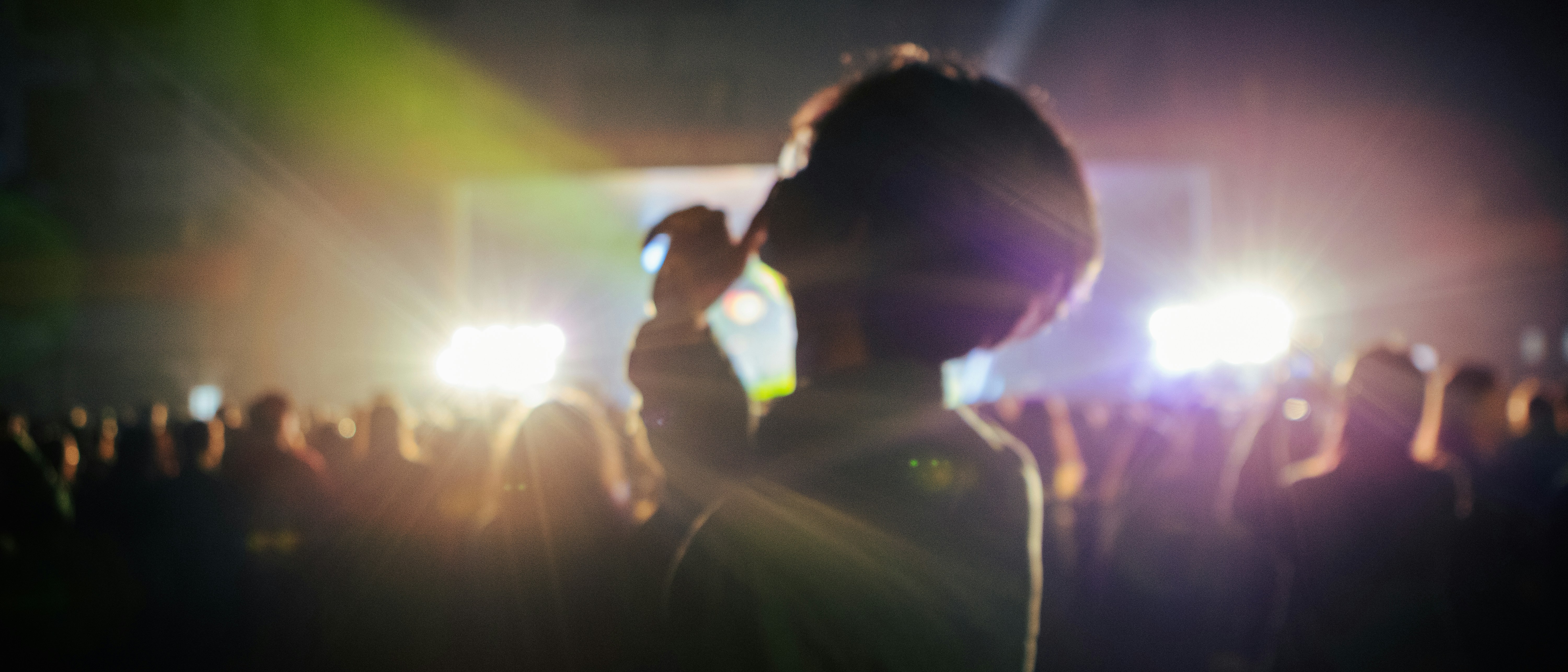Crowd watching concert with bright stage lights