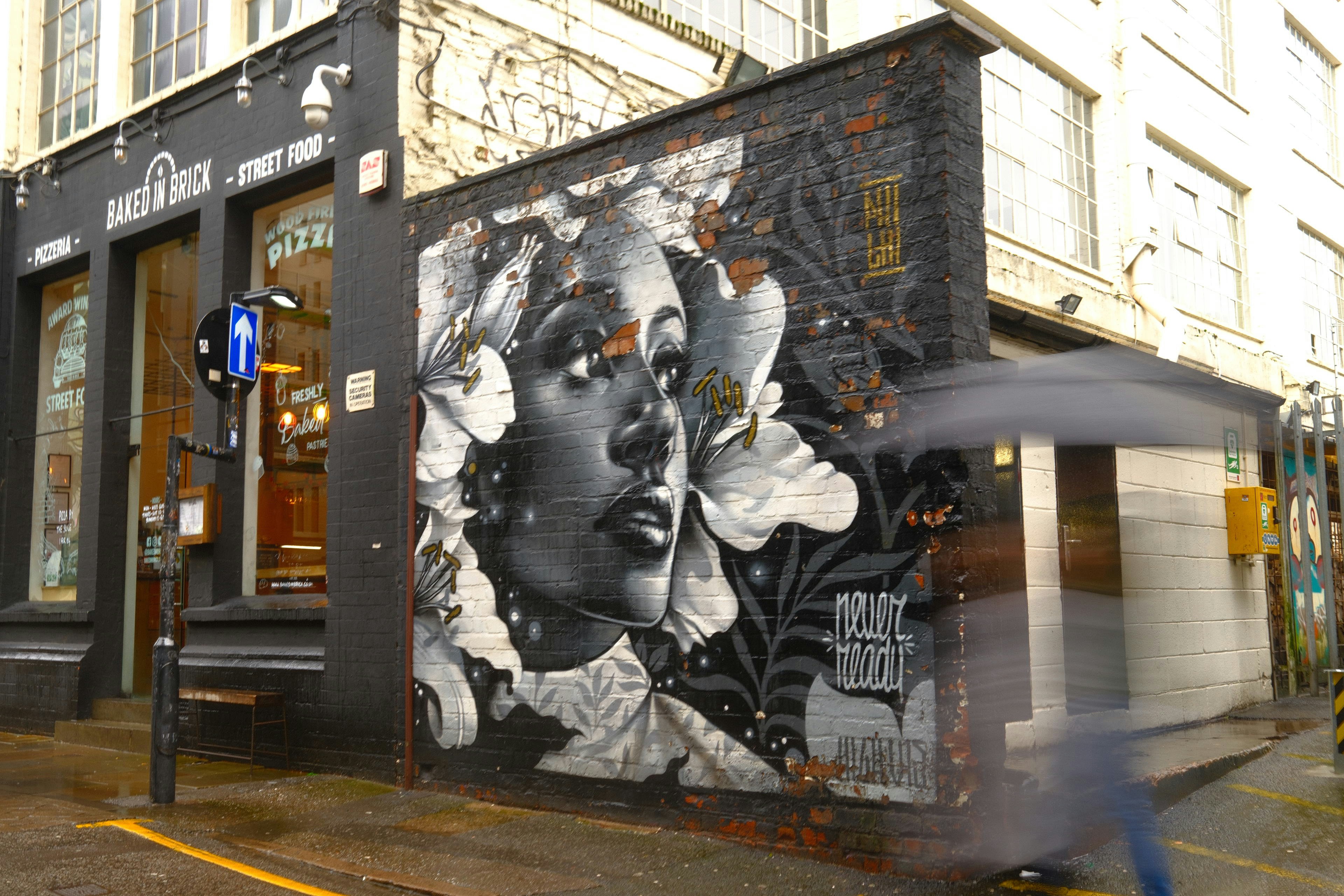 Graffiti mural of a woman's face on a brick wall