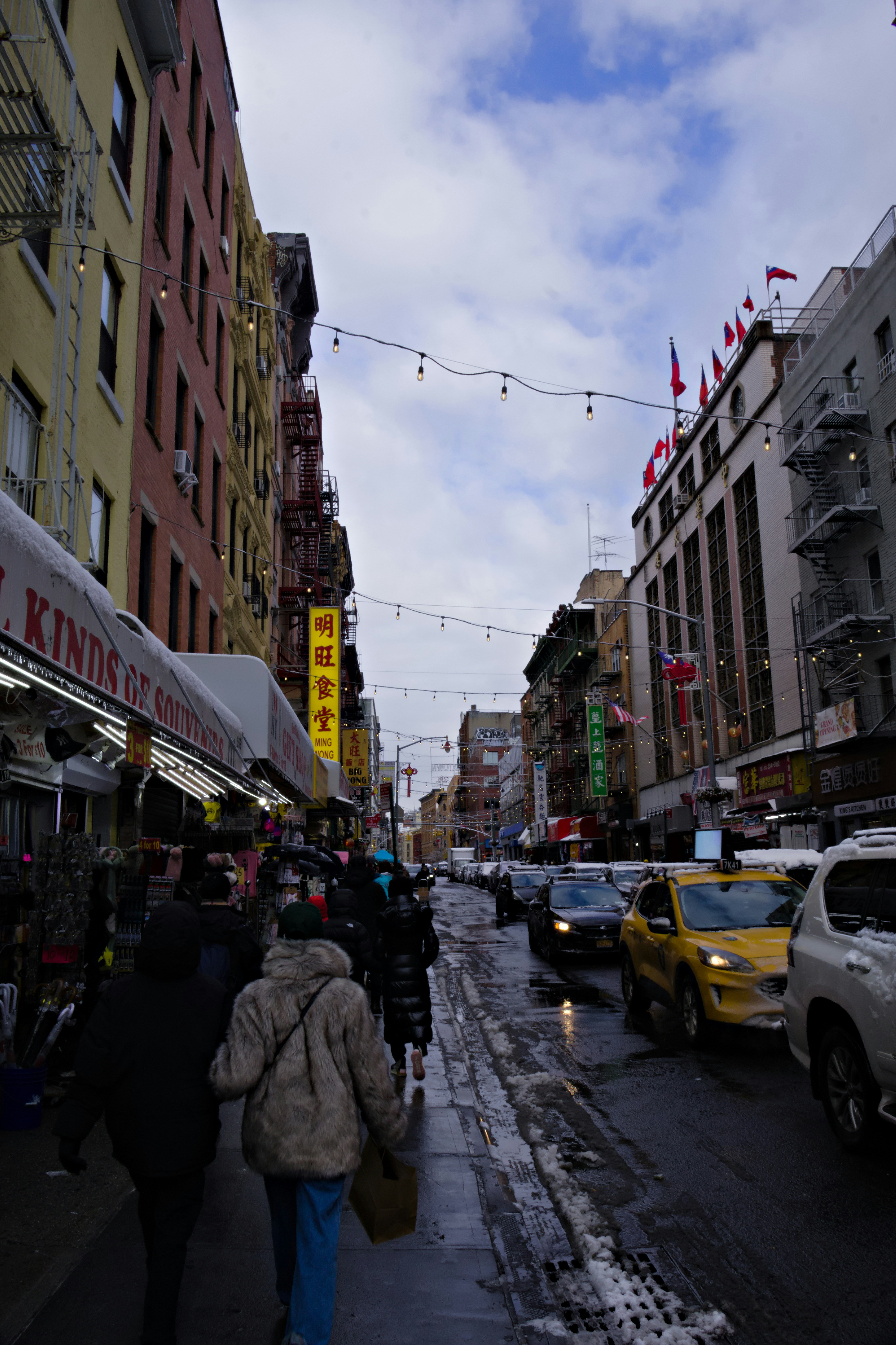 People walking down a wet street in chinatown