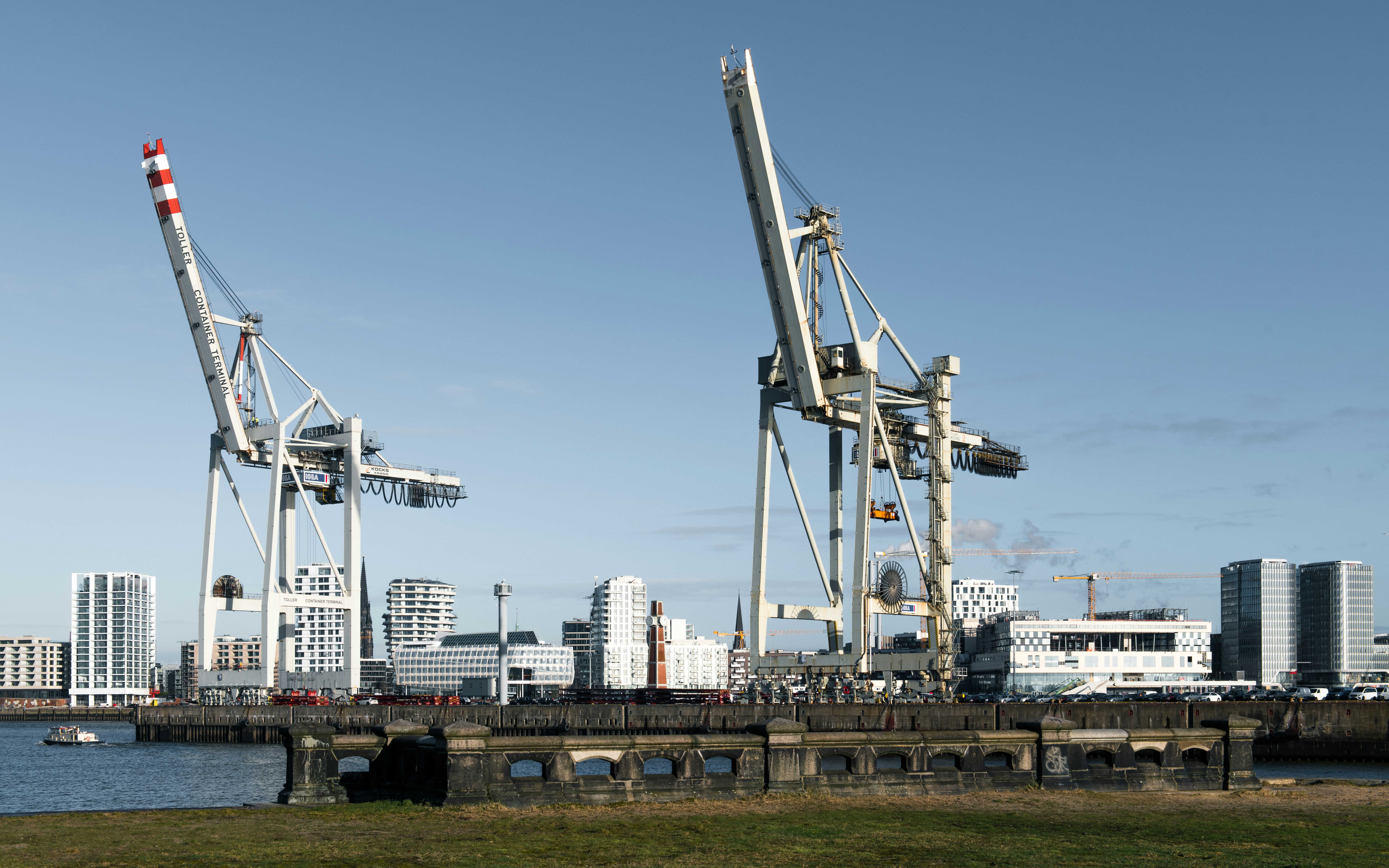 Two large cranes stand against a clear blue sky.