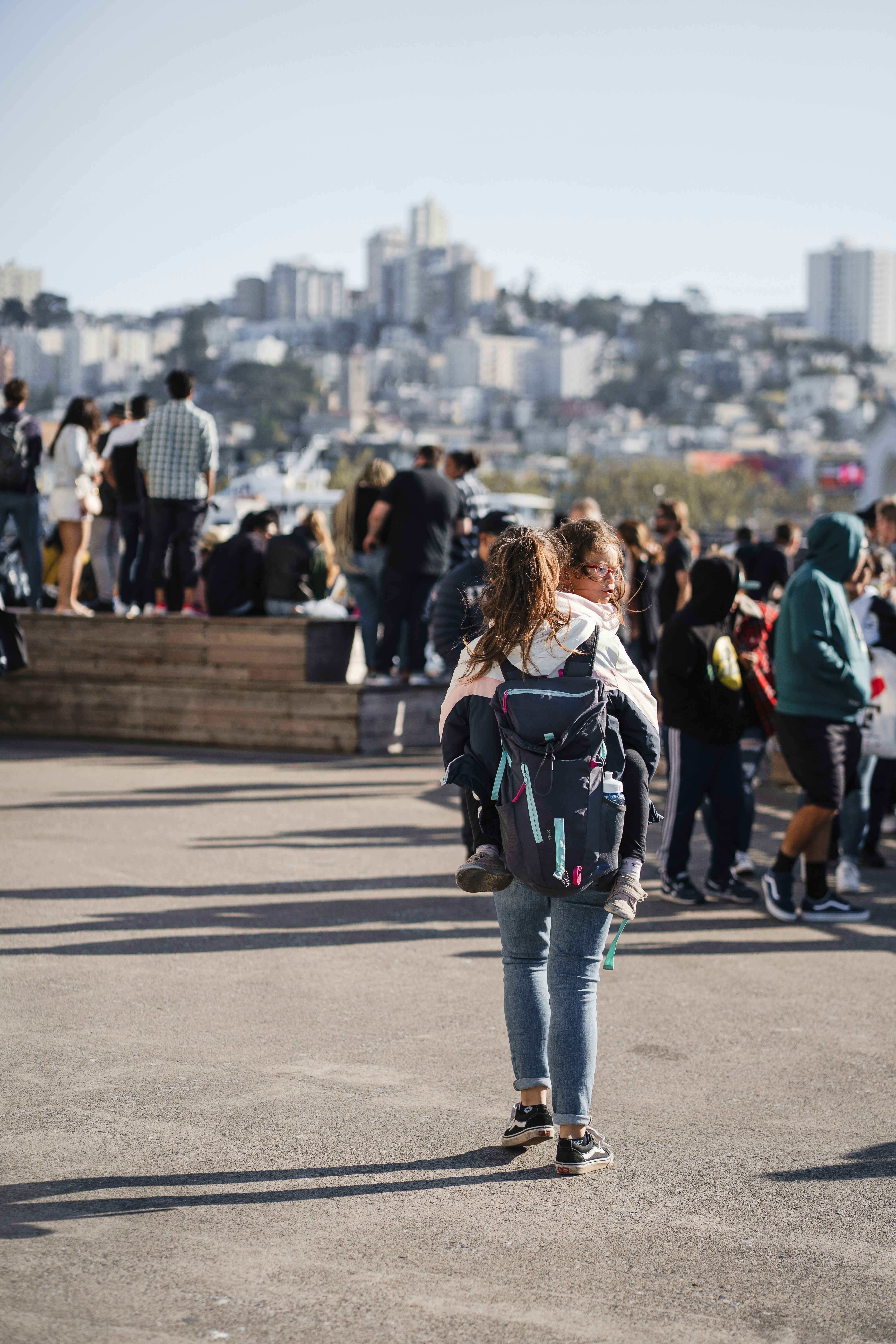 Woman carrying child with city skyline in background