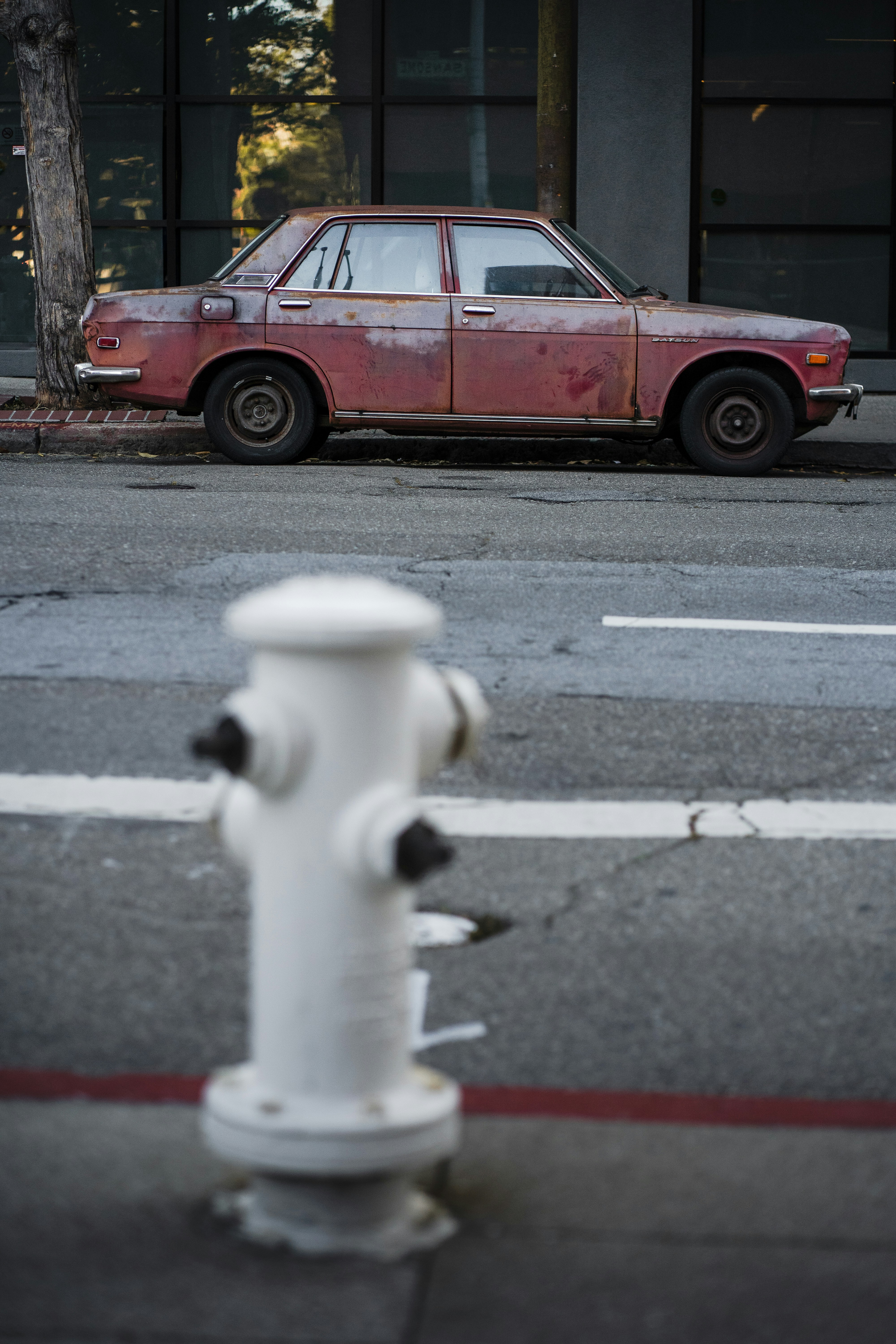 Rusty vintage car parked on a city street