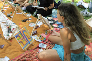 People painting outdoors at an art class.