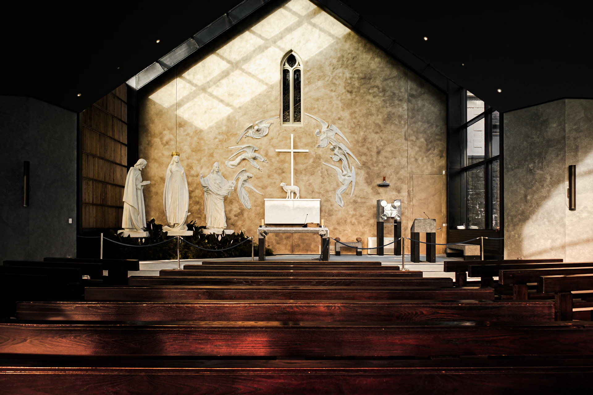 Interior of a modern church with wooden pews and altar.