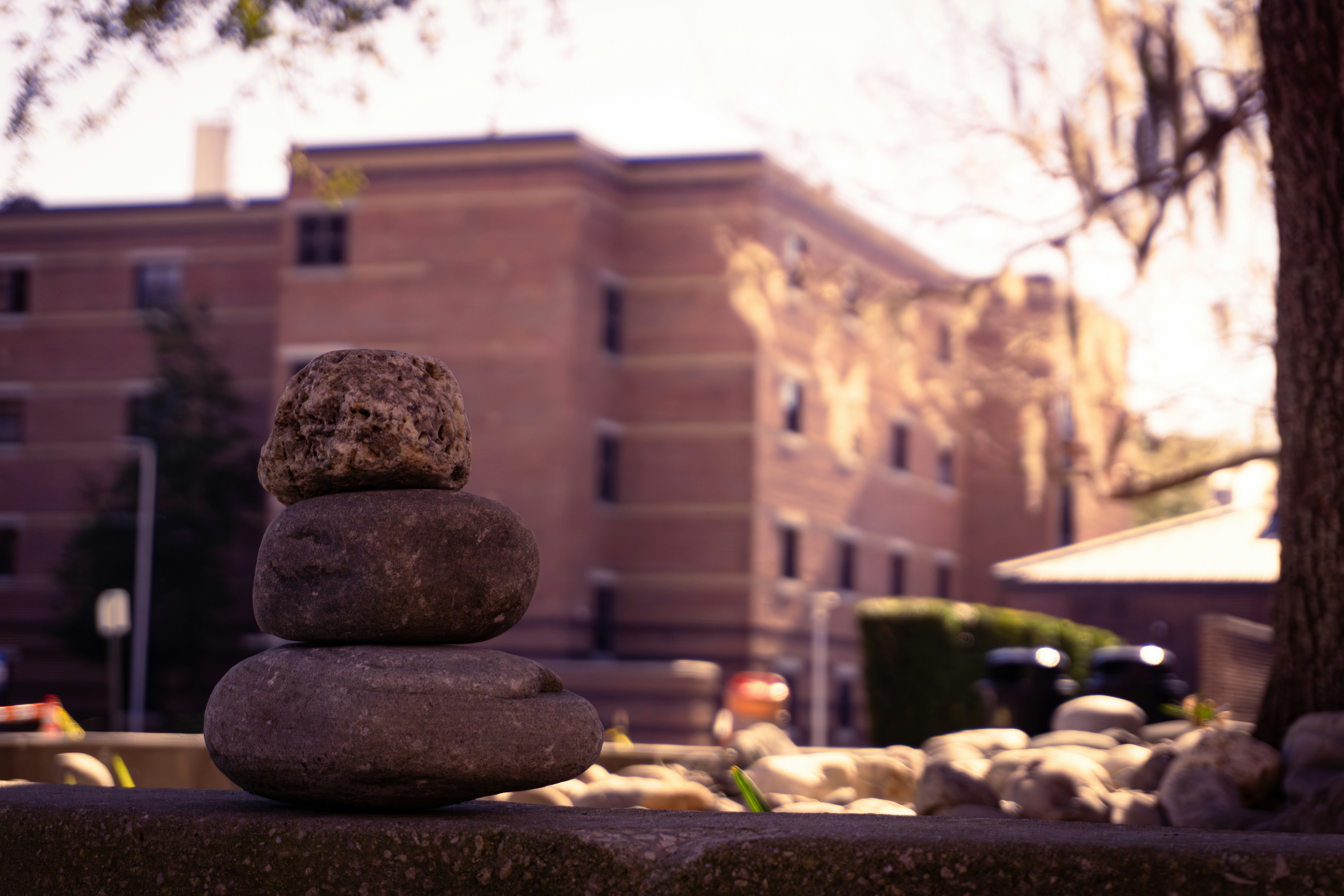 Stack of balanced stones in front of a brick building