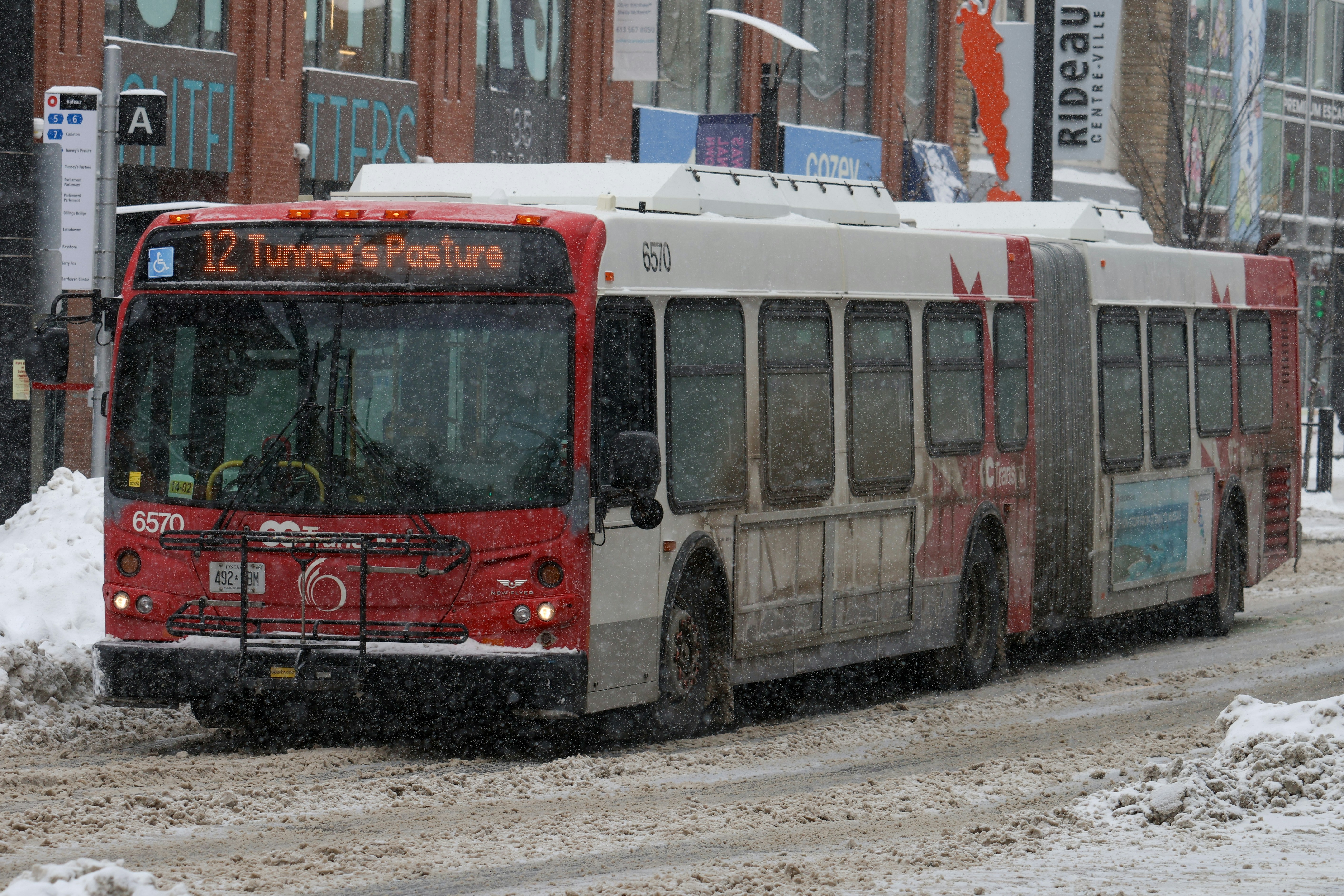 Un autobus articolato rosso e bianco che viaggia nella neve.