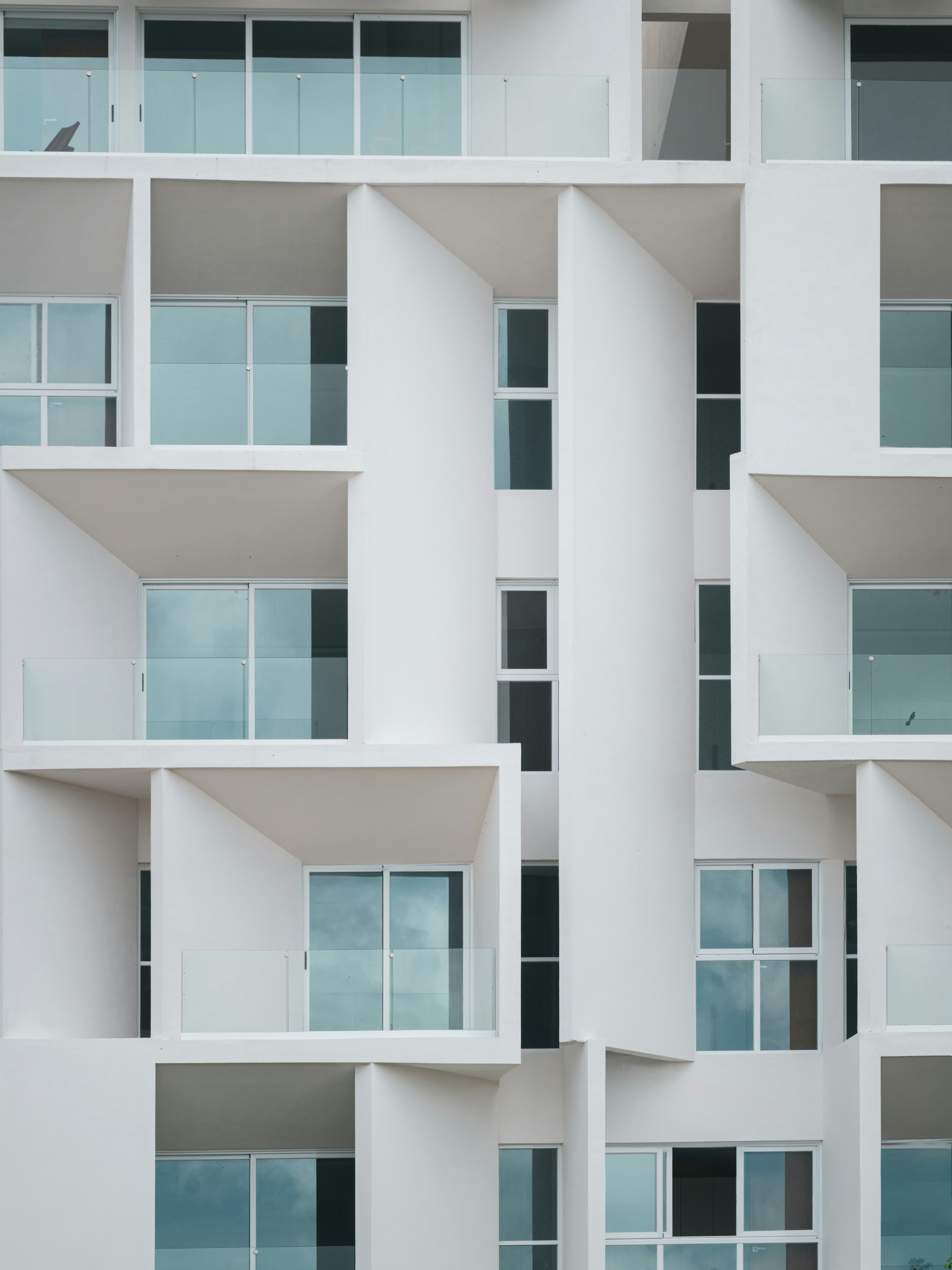 Modern white building with geometric balconies and windows