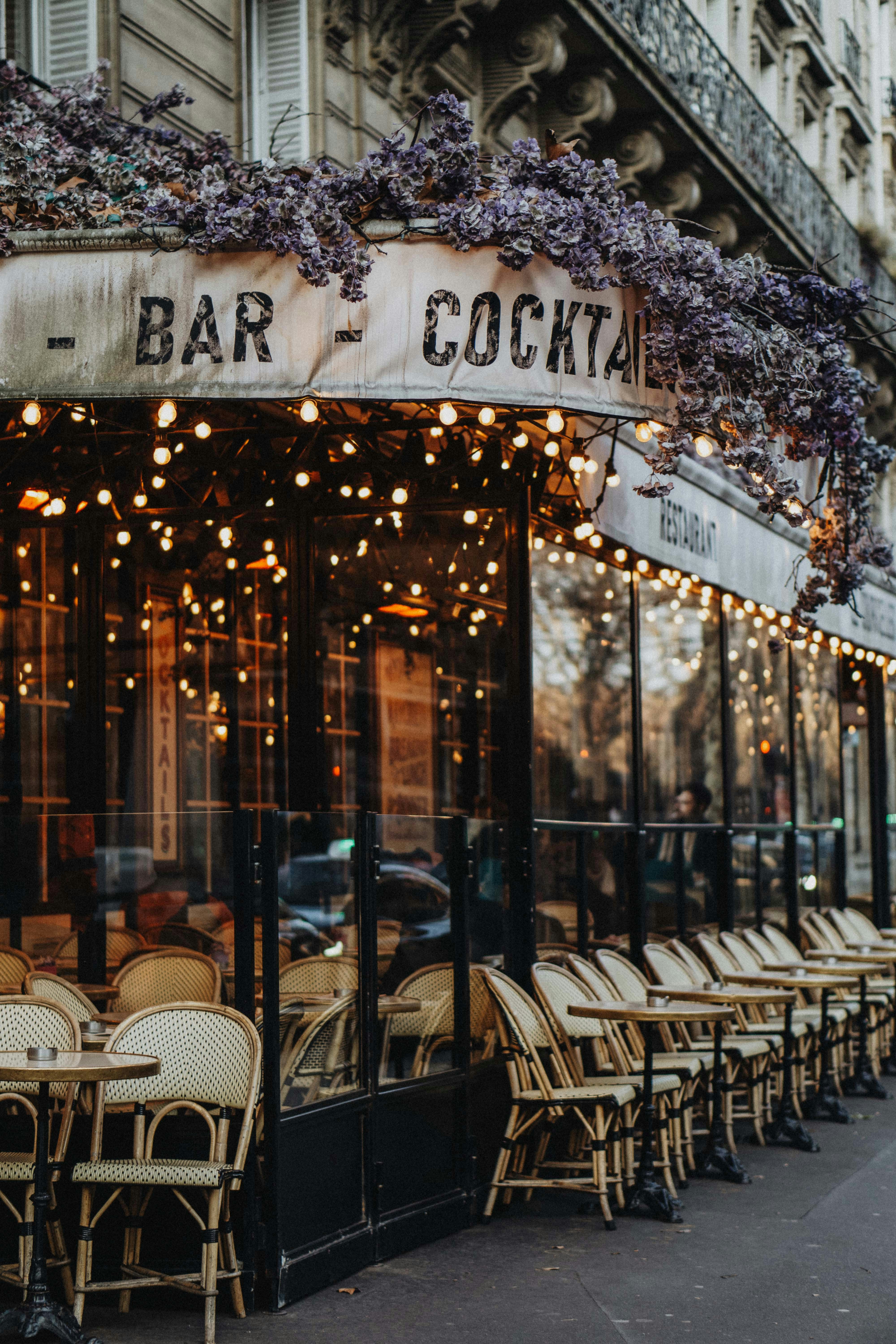 Outdoor cafe seating with string lights and flowers