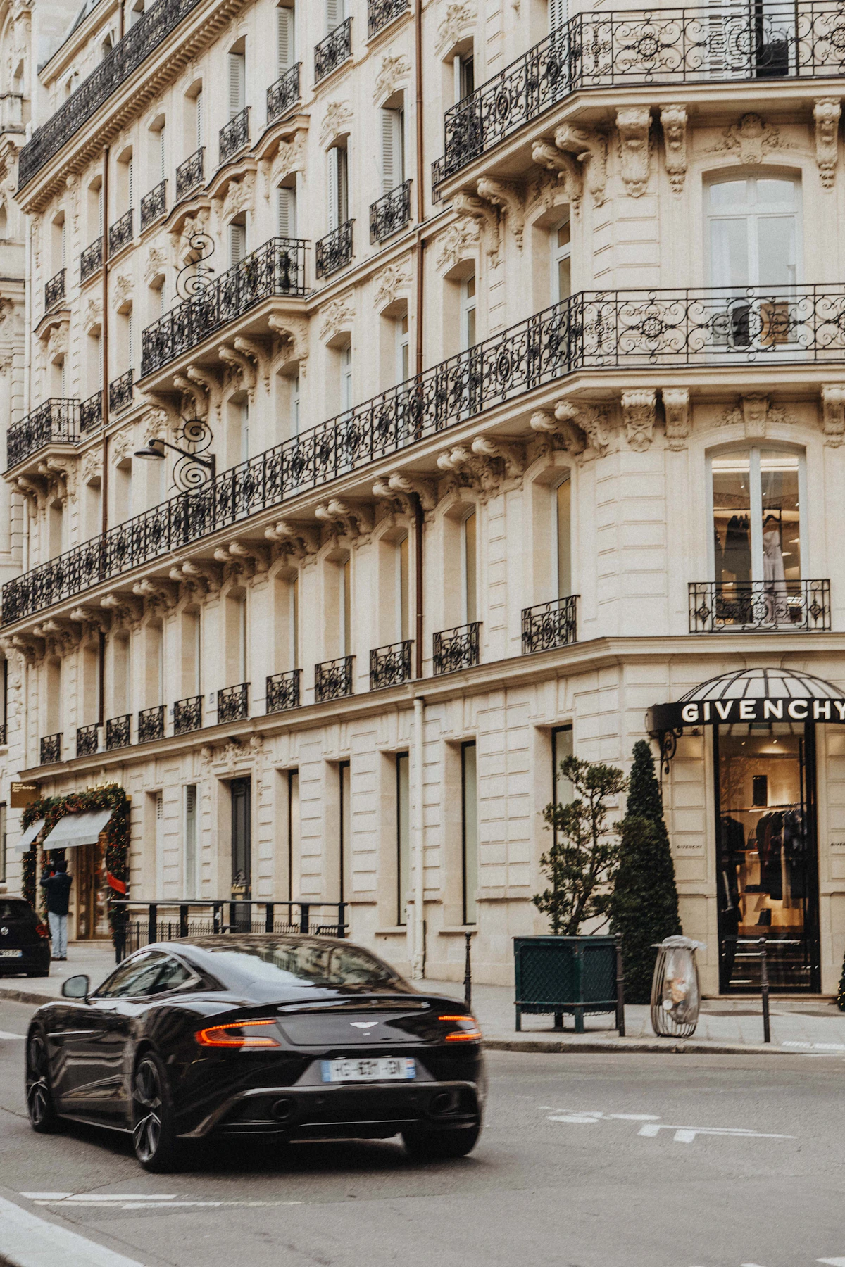 Une berline noire devant une façade haussmannienne