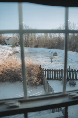 Snowy backyard seen through a windowpane
