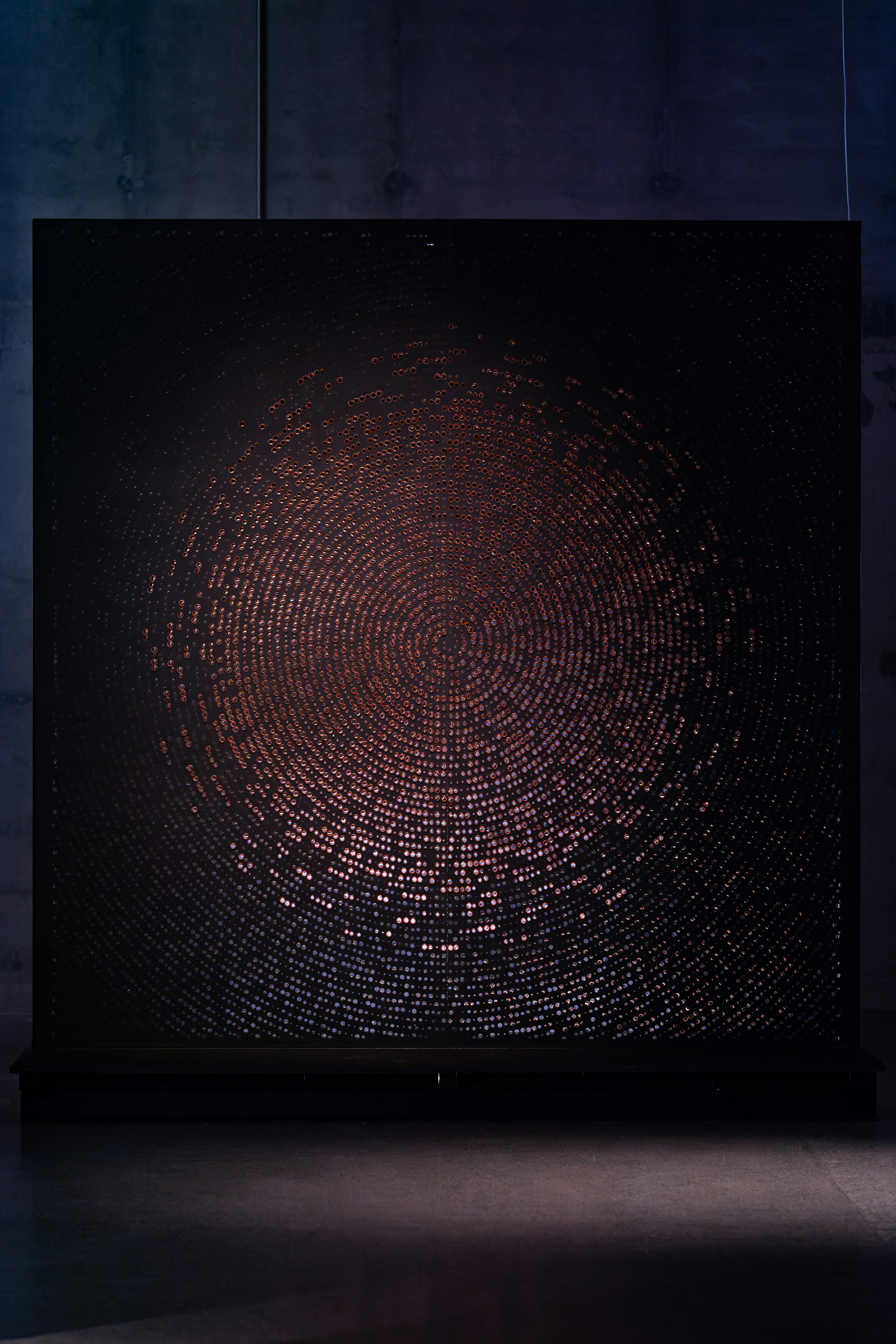 Circular mosaic with glowing center on dark background