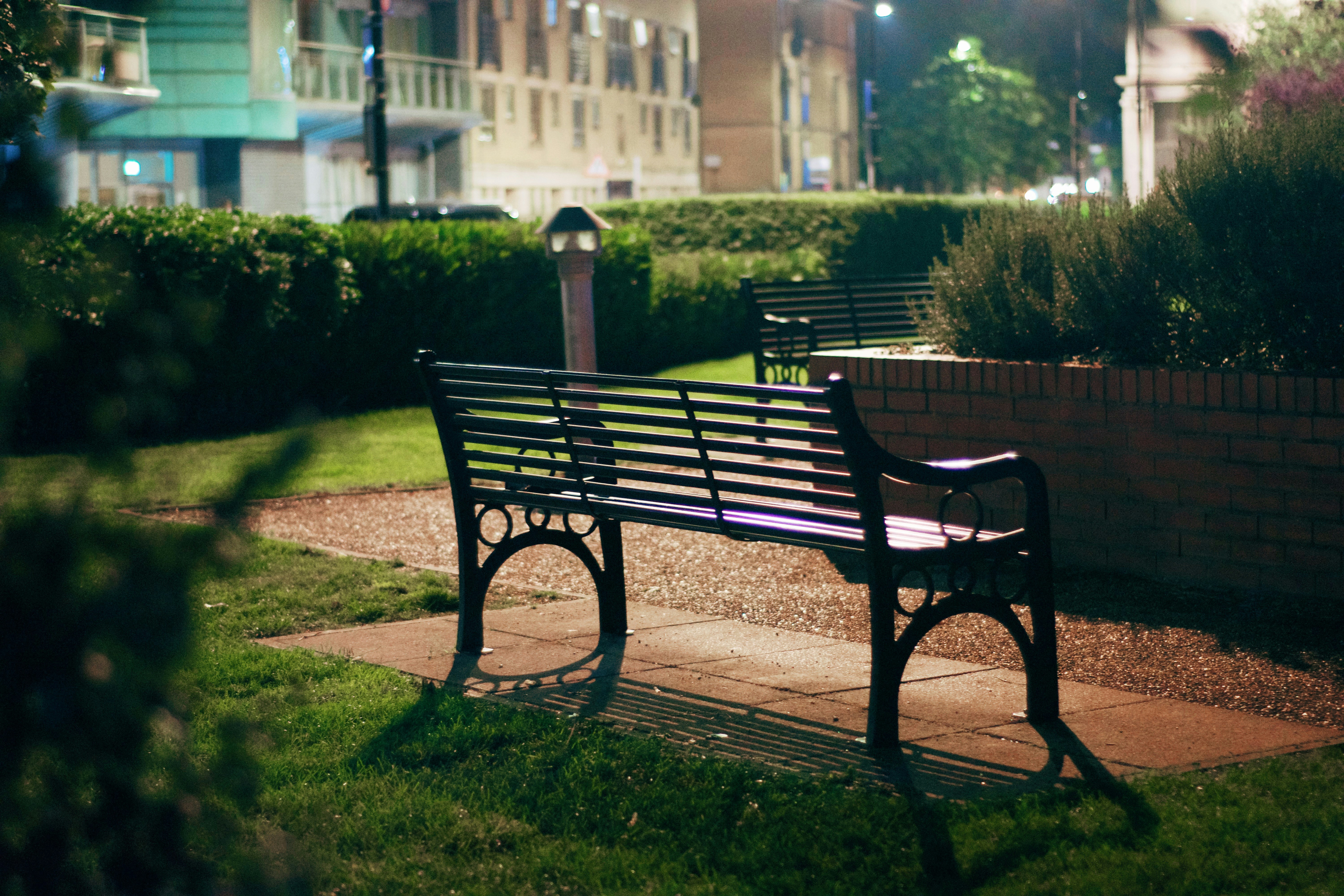 Banco vacío en el parque por la noche con luz suave.