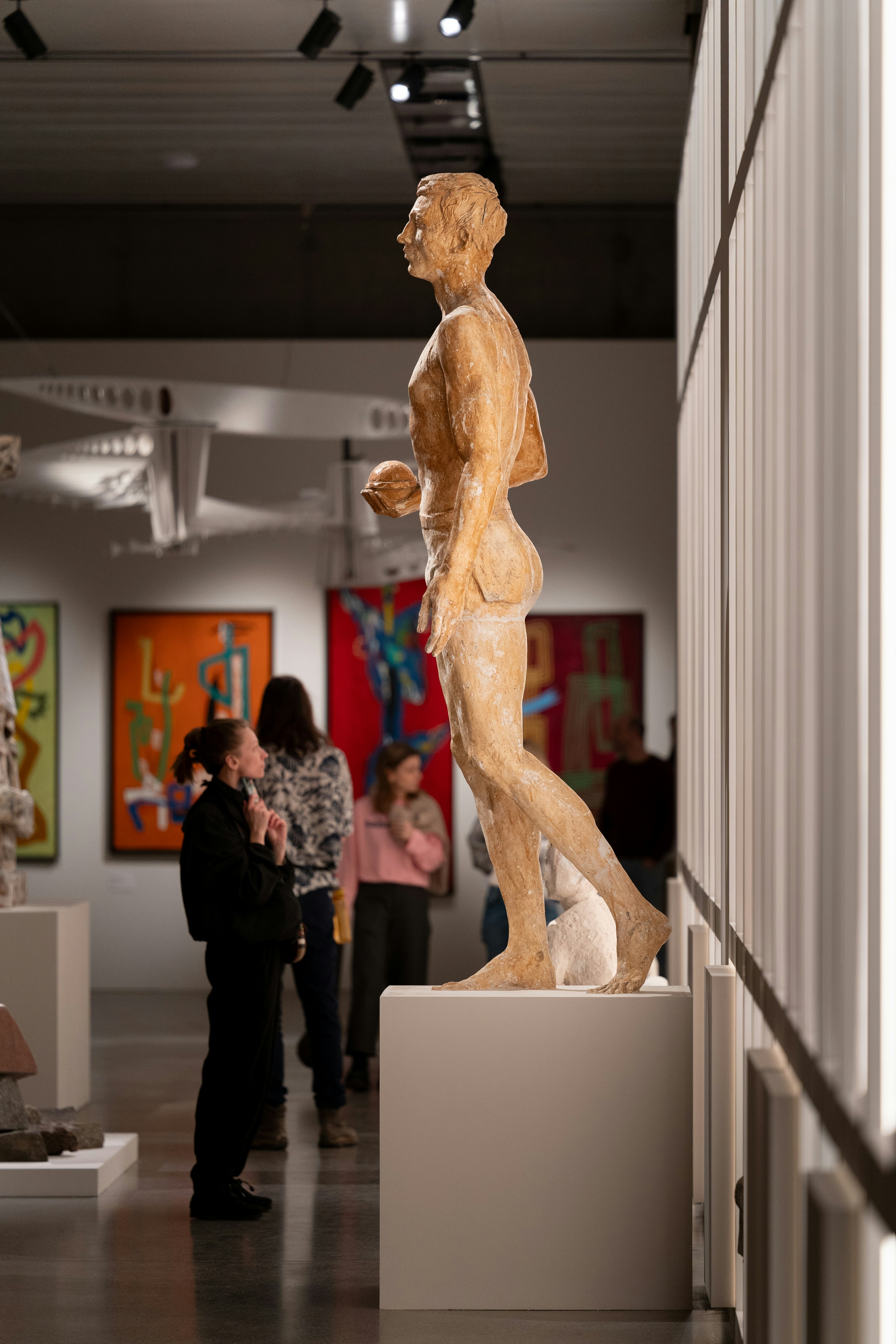 People observe a sculpture in an art gallery
