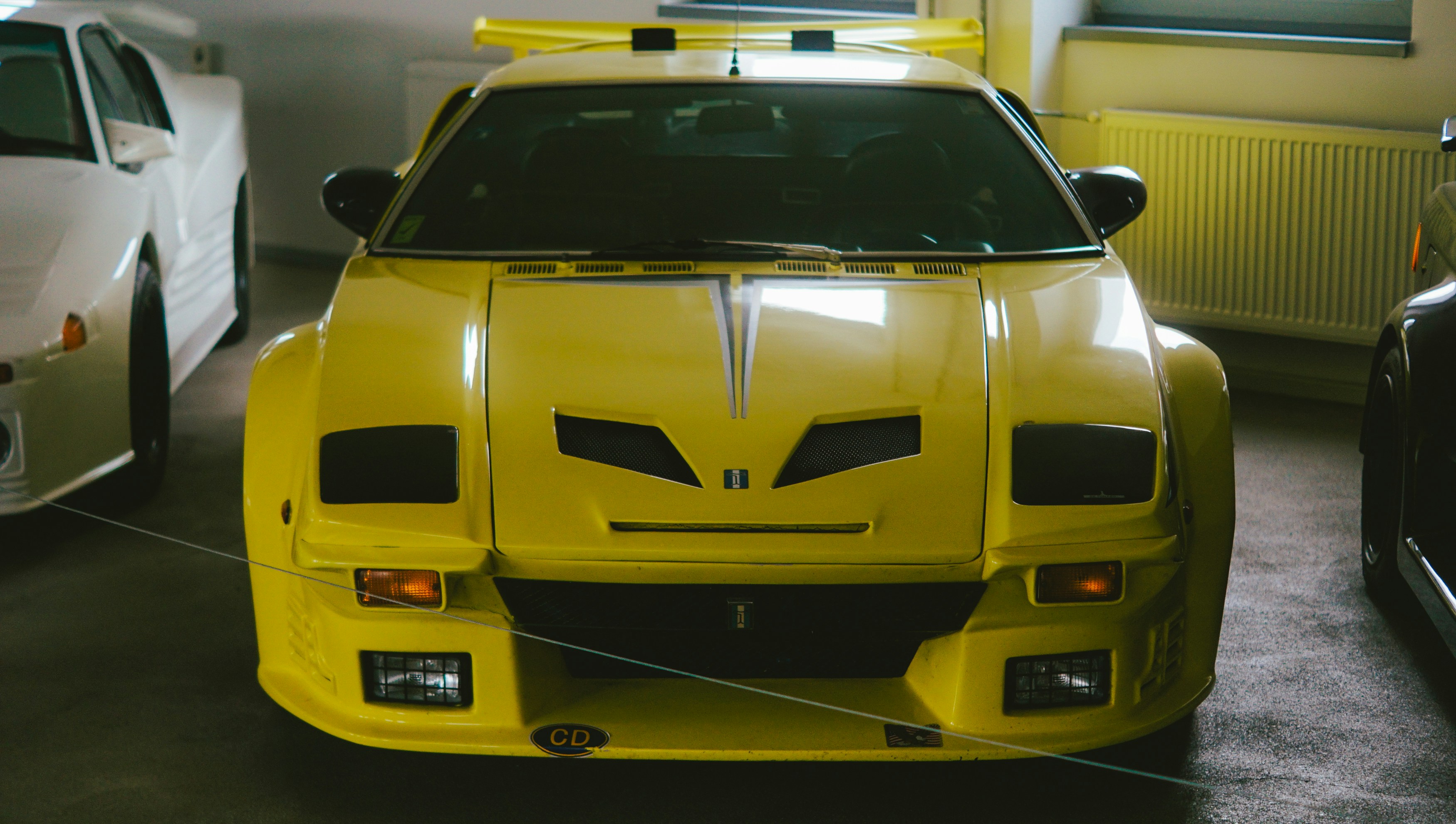A bright yellow sports car with a spoiler