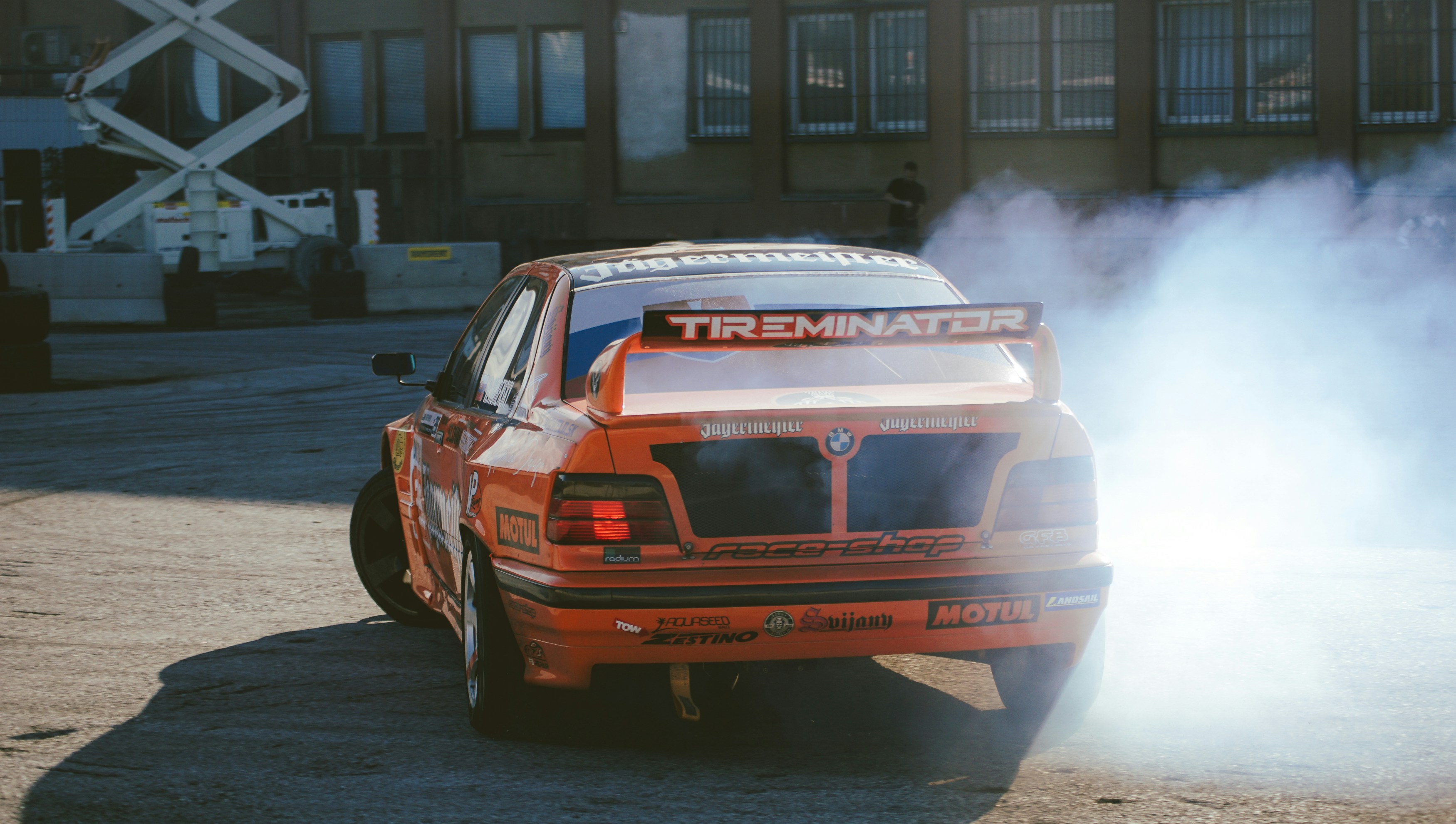 Orange race car drifting with smoke
