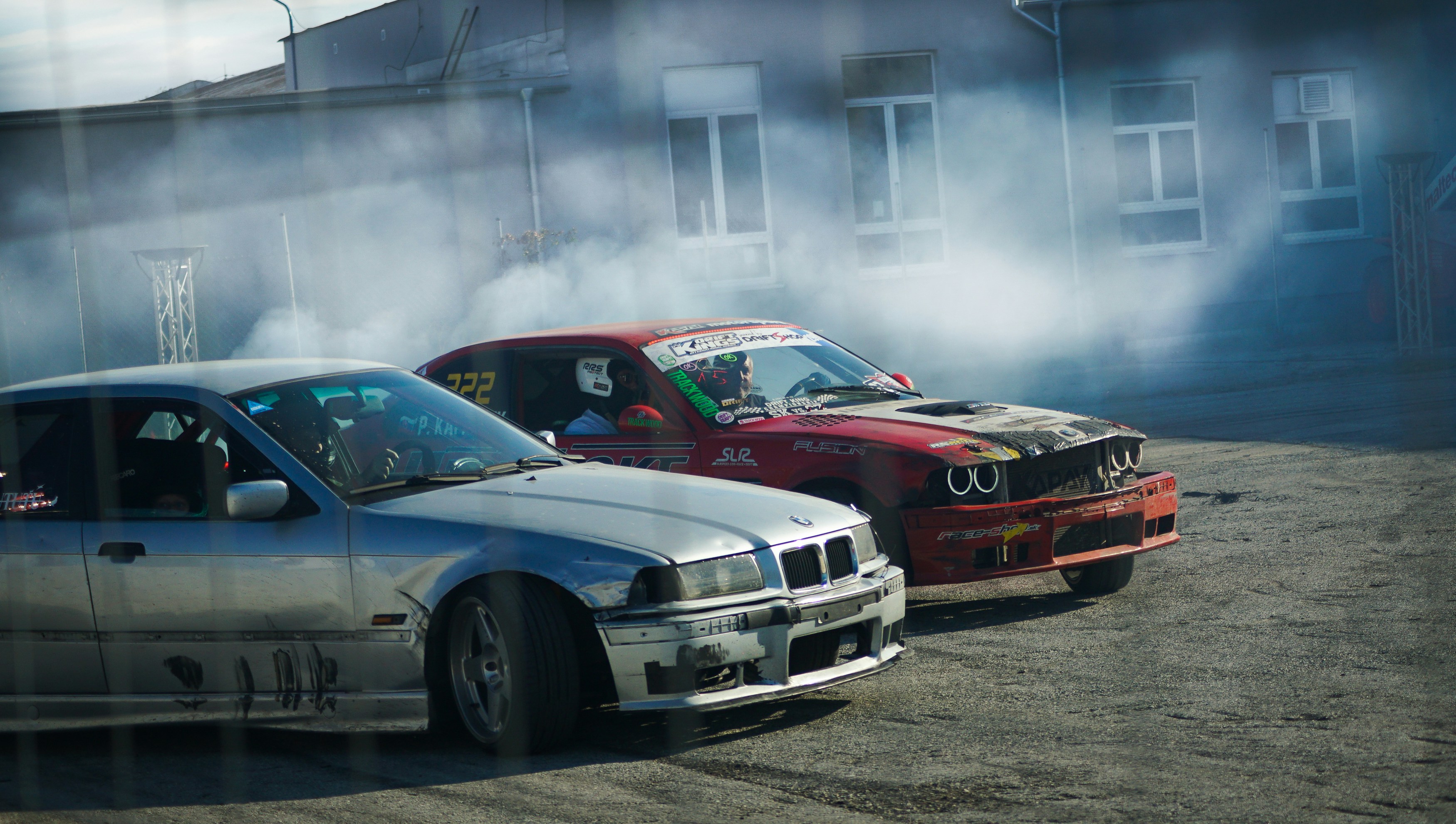 Two cars drifting in smoke on asphalt