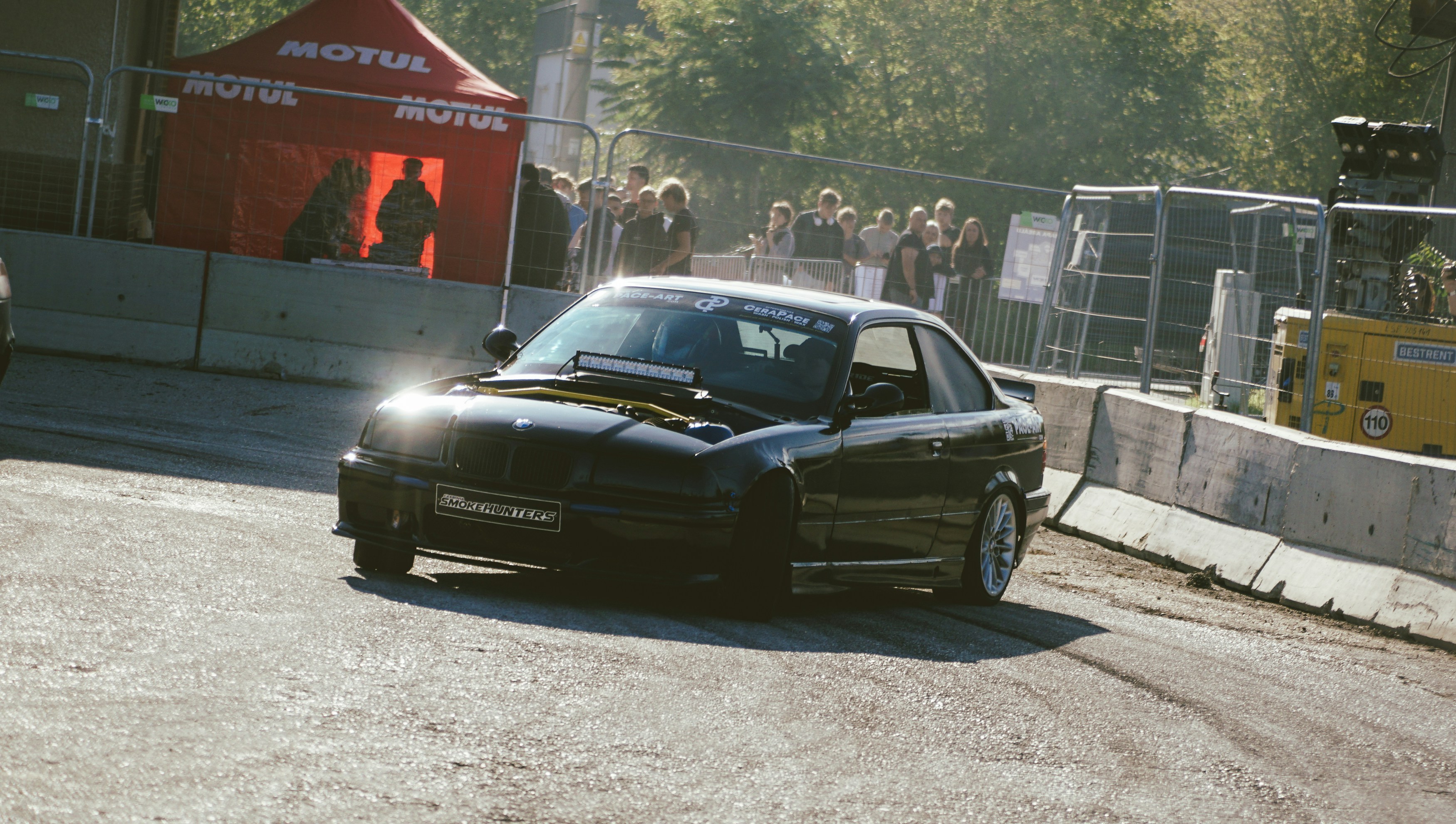 A black sports car drifts around a corner.