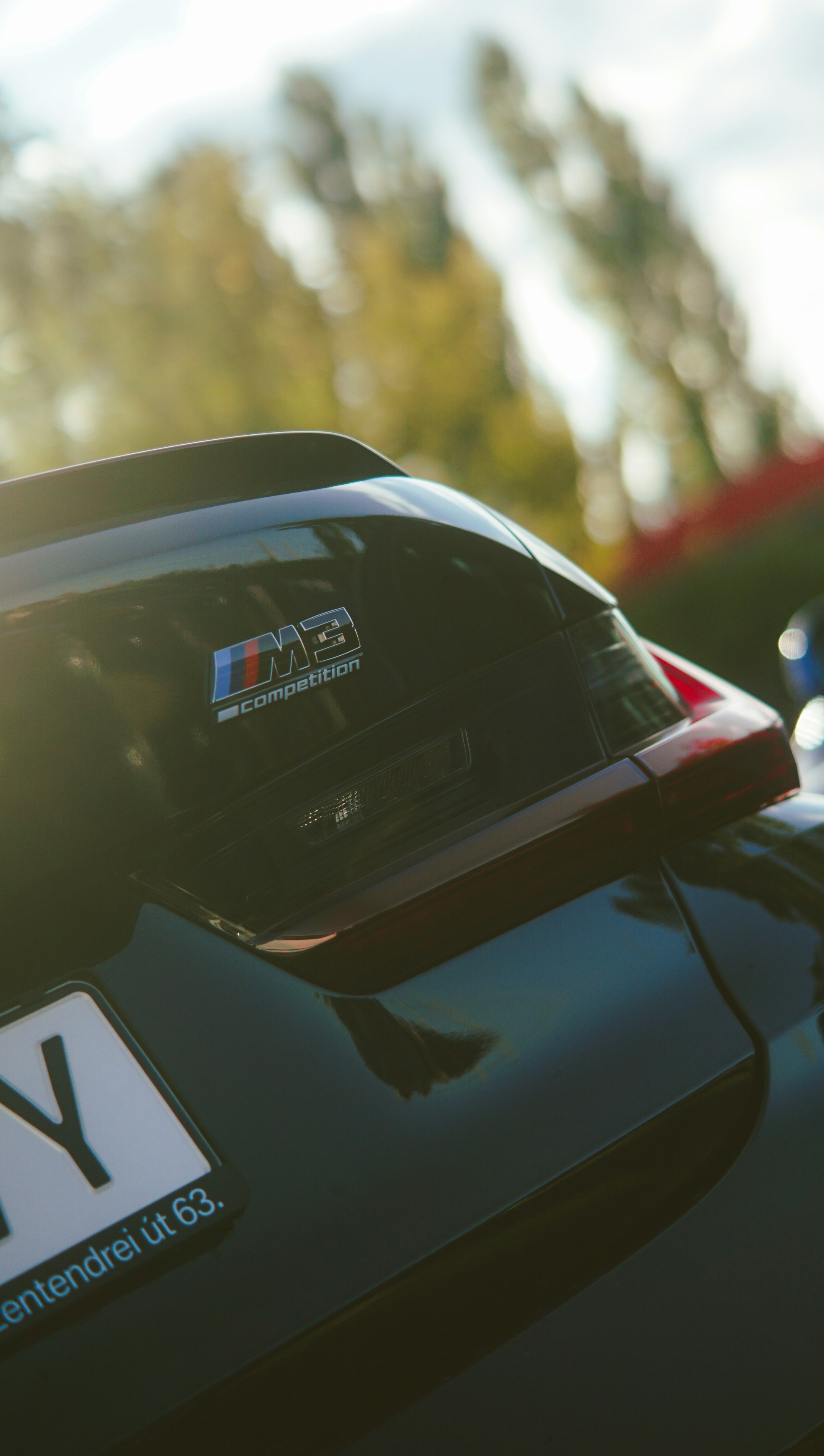 Black car with m3 competition badge and license plate.