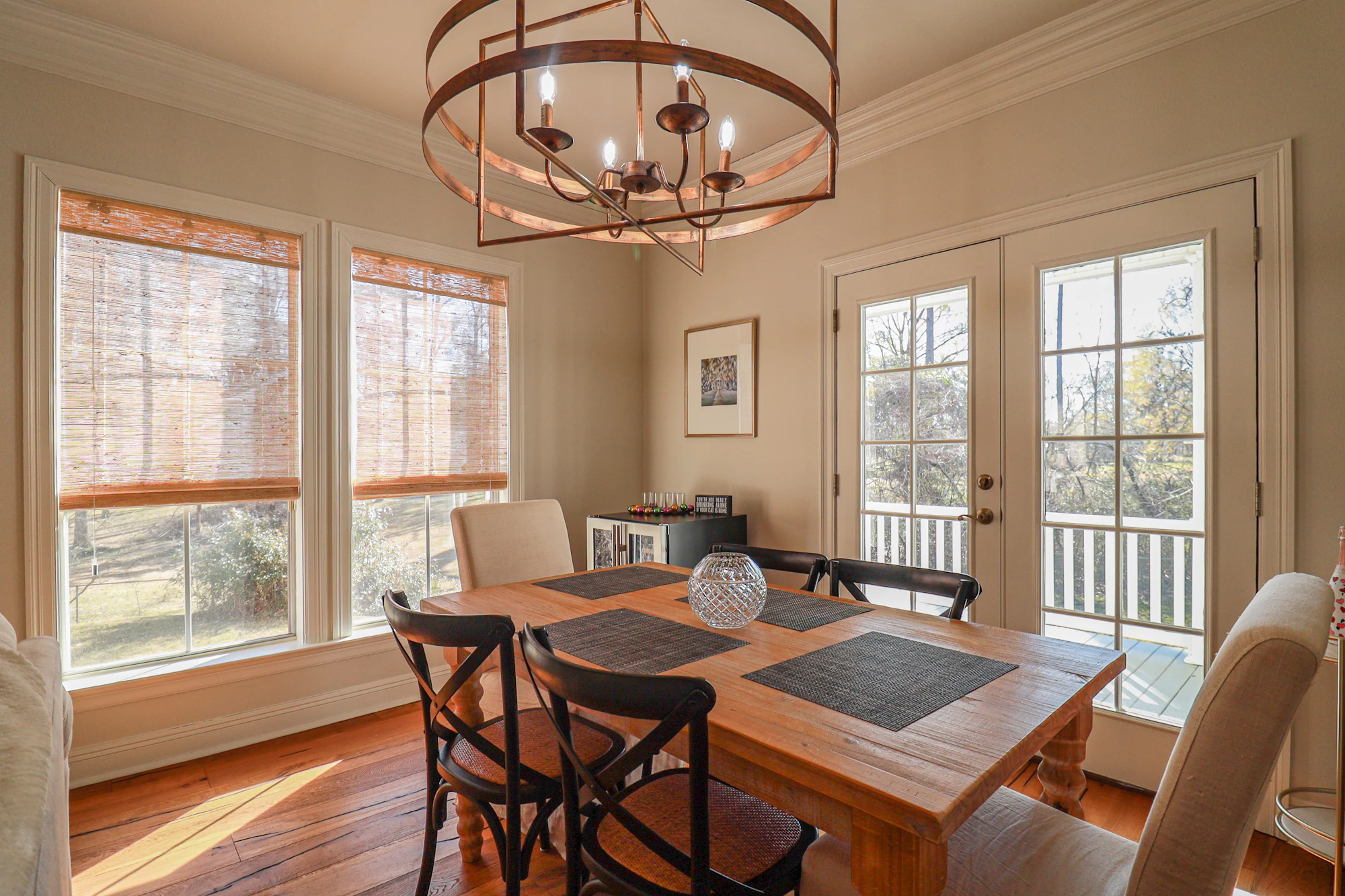 Warm dining room with tall windows dressed in woven-wood blinds