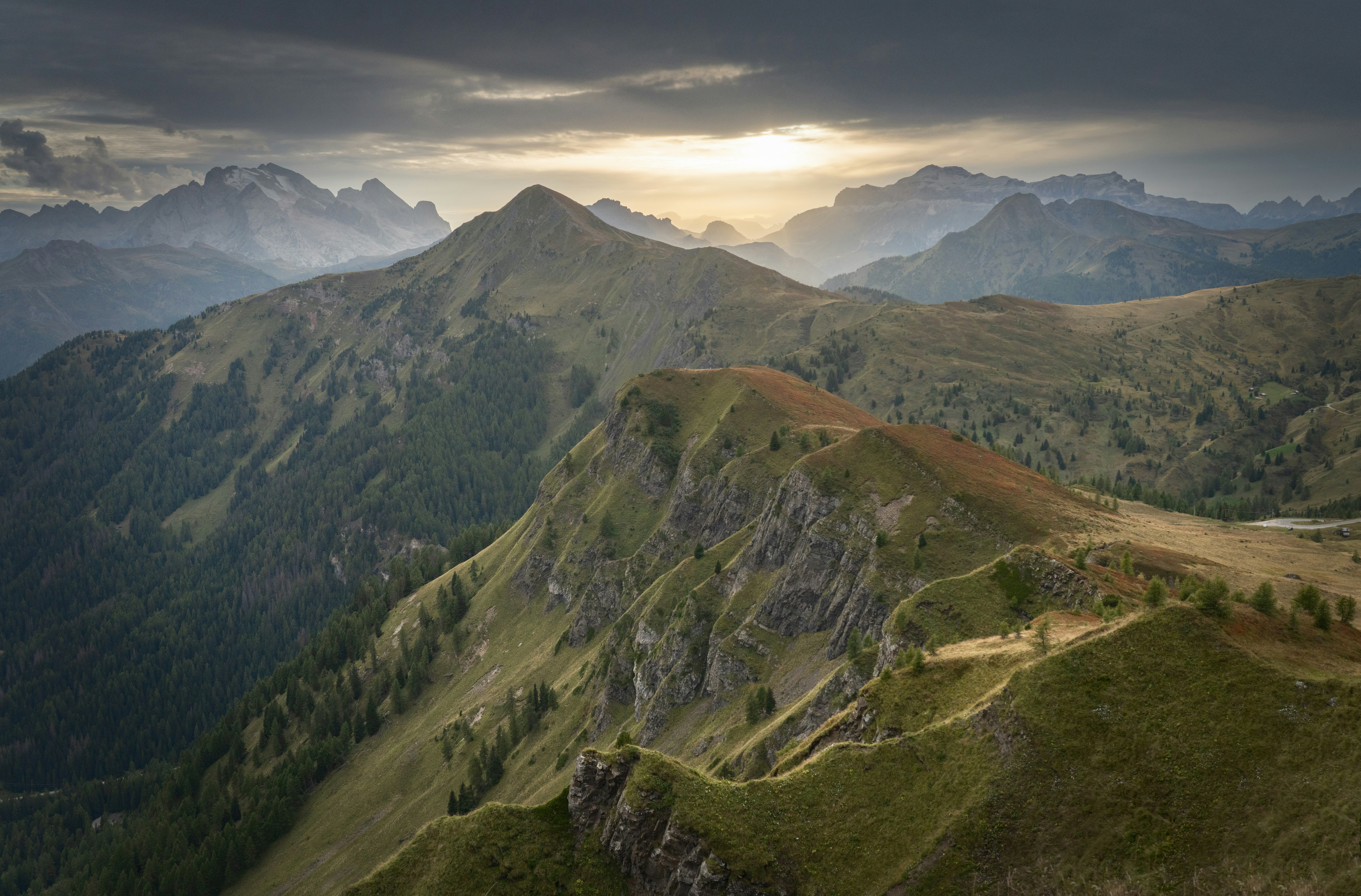 Catena montuosa drammatica con il sole che filtra tra le nuvole