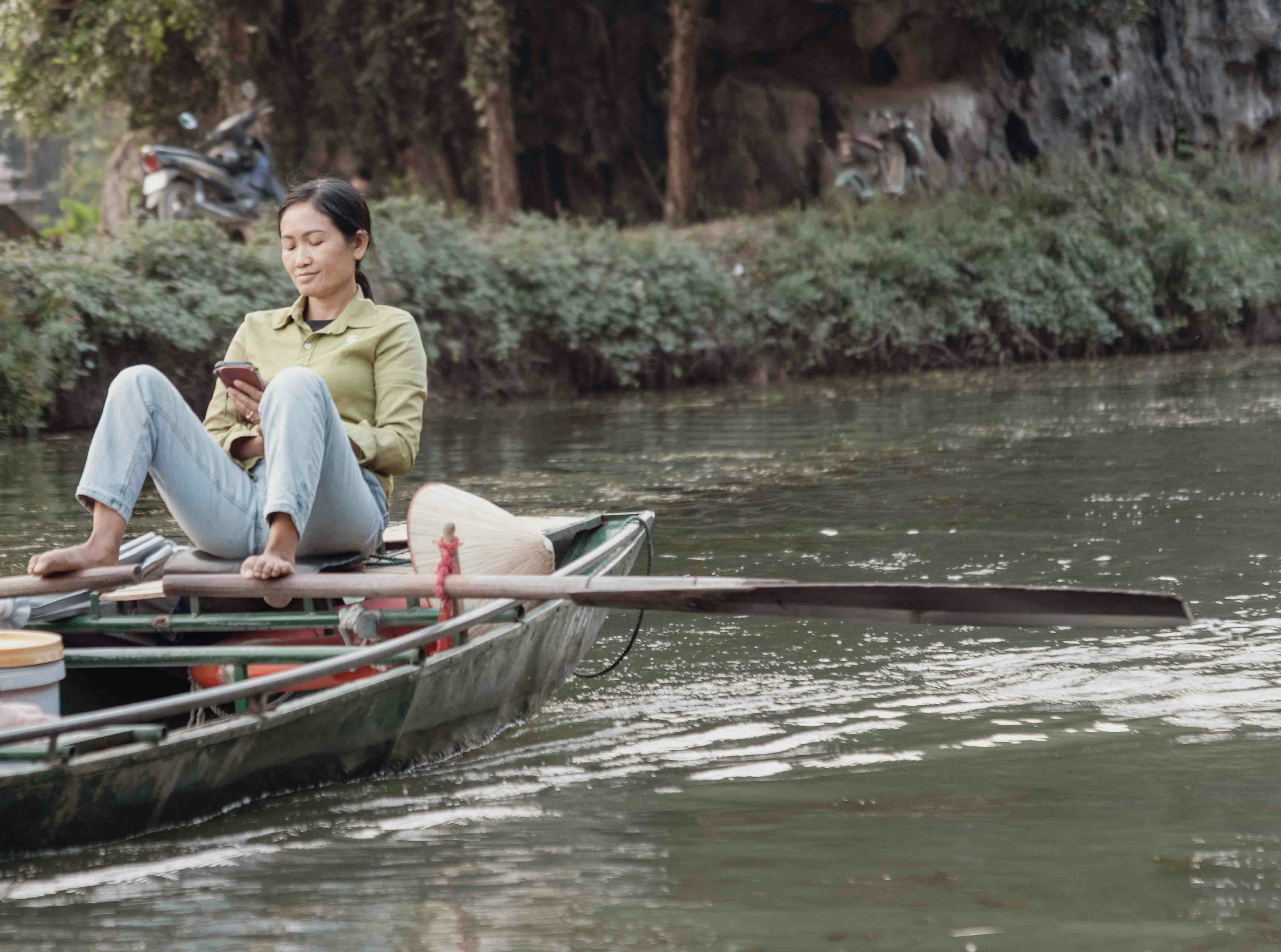 Woman in a boat looking at her phone