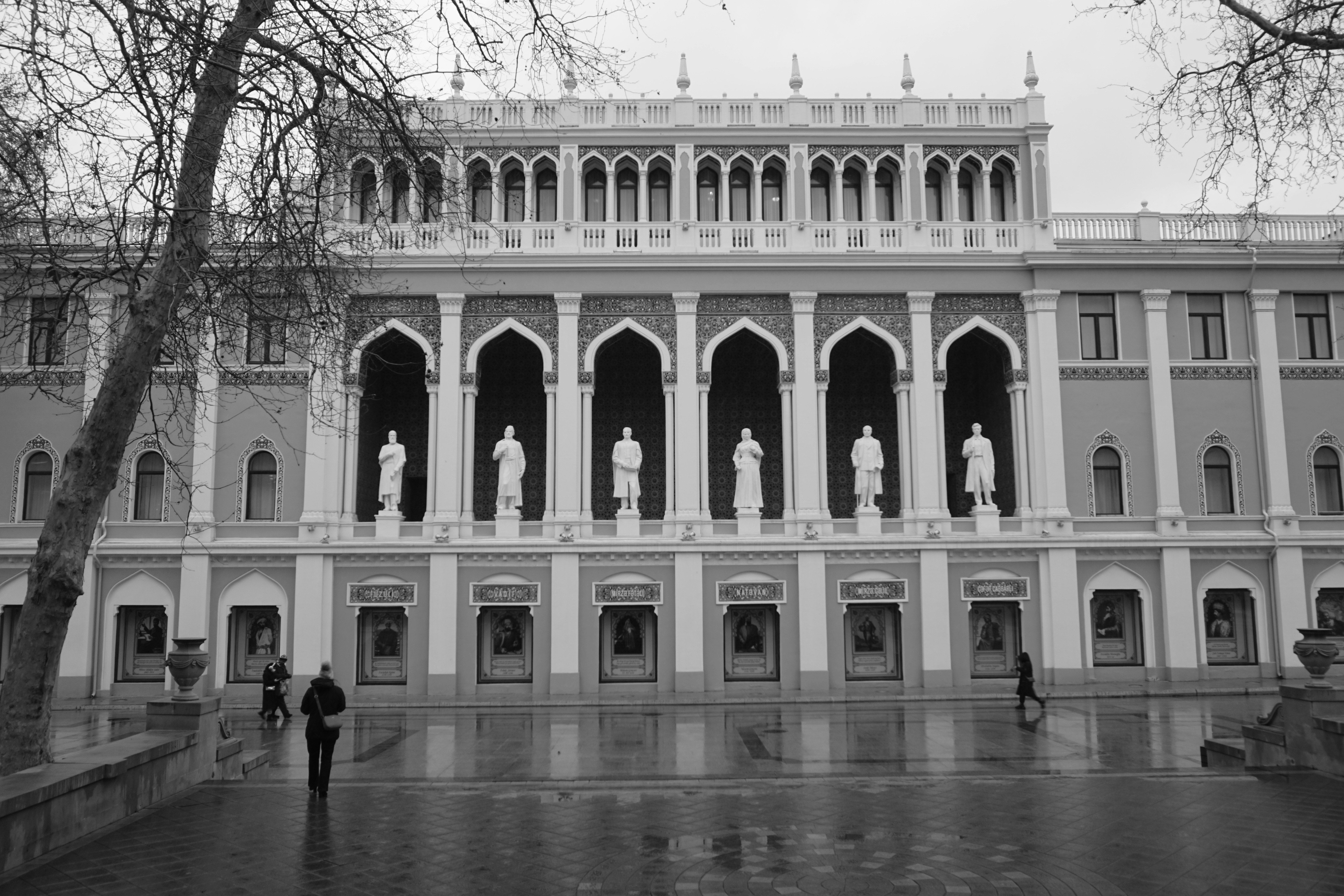 Ornate building facade with statues and arched windows.