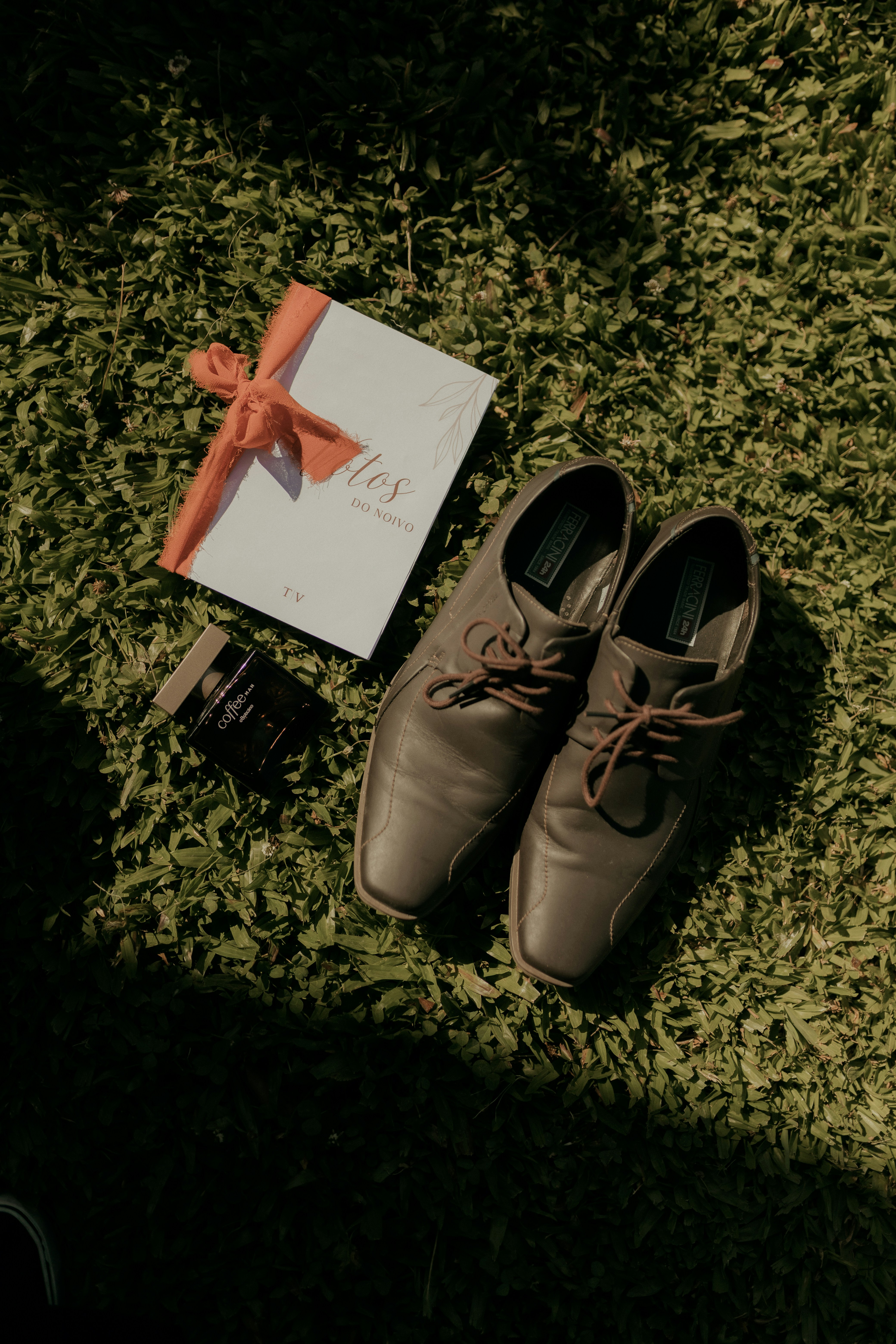 Braune elegante Schuhe, eine Karte und Zigaretten auf Gras