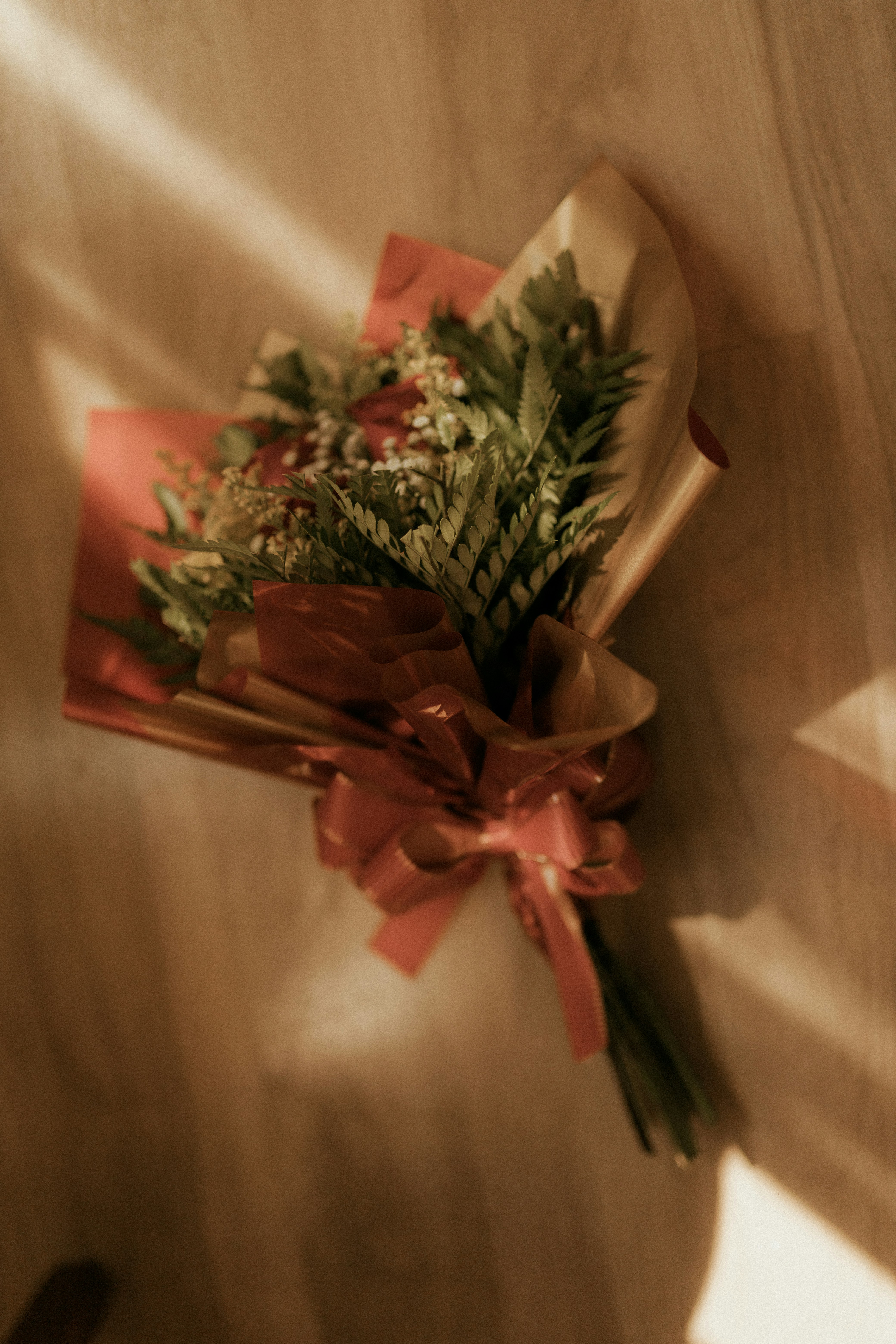 A bouquet of red roses with greenery and green leaves.