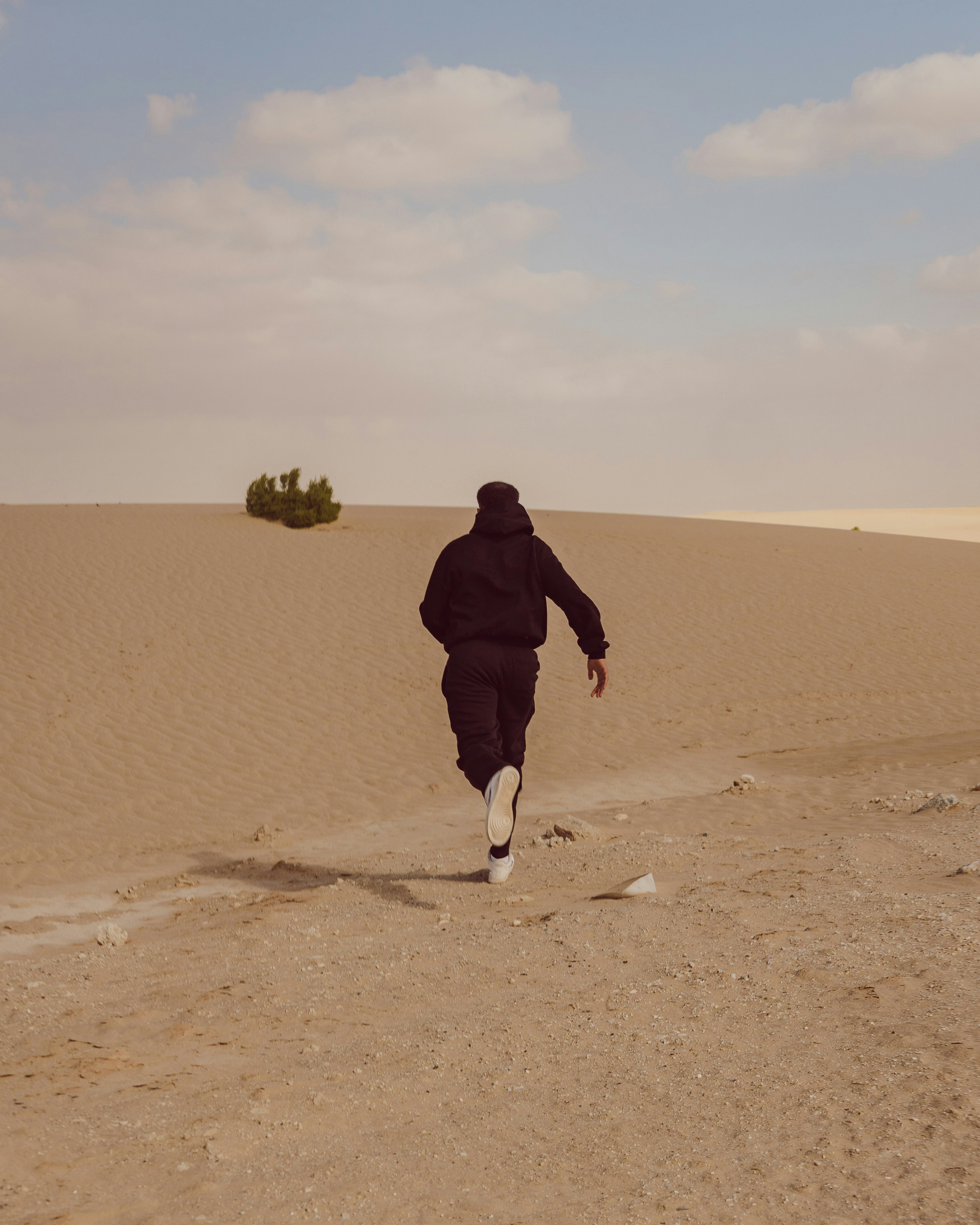 広大な砂漠の風景を走る人物