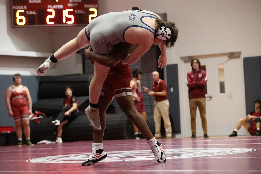 Two wrestlers competing intensely on the mat during a professional grappling match