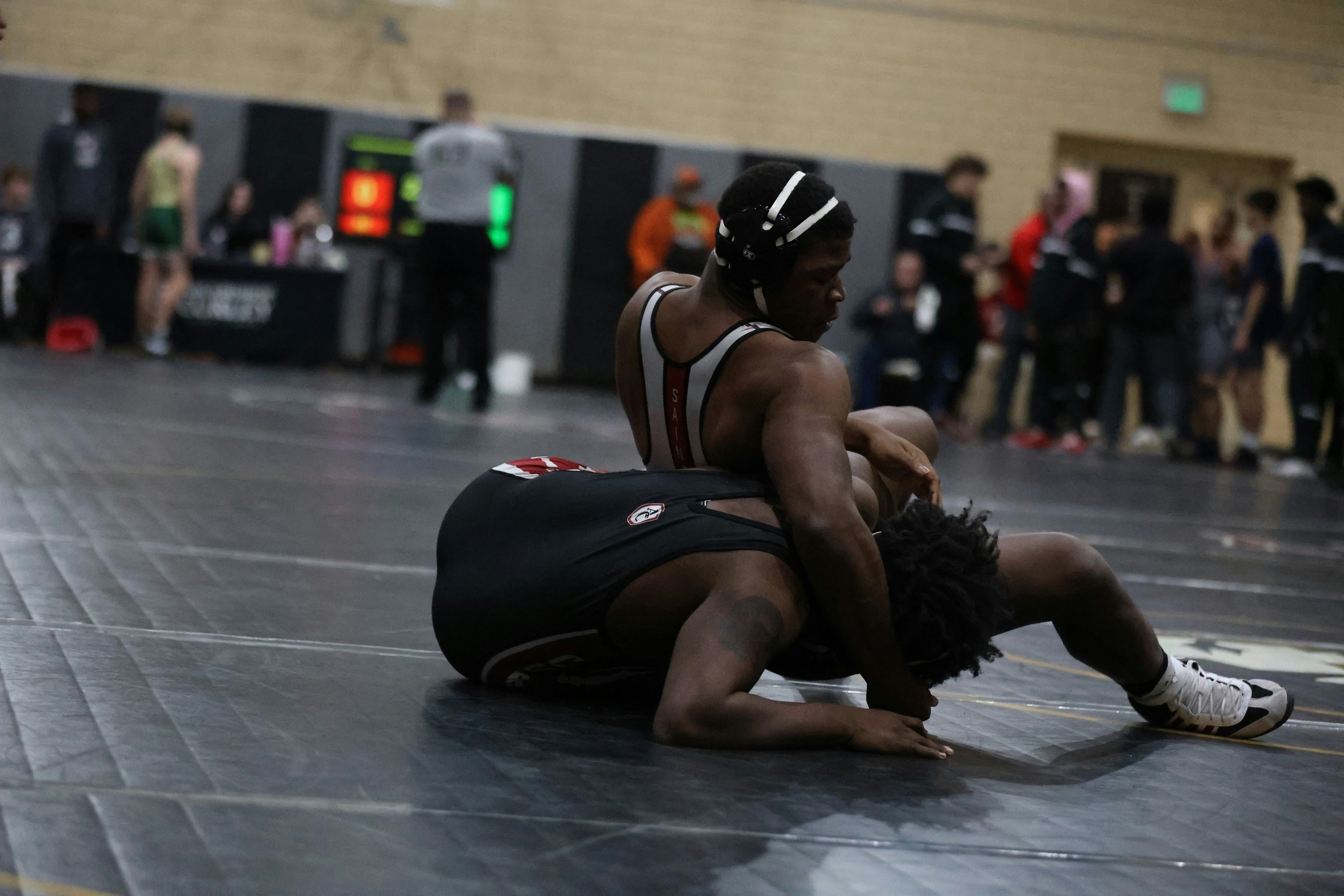 Two grapplers engaged in an intense no-gi submission grappling match on the competition mat