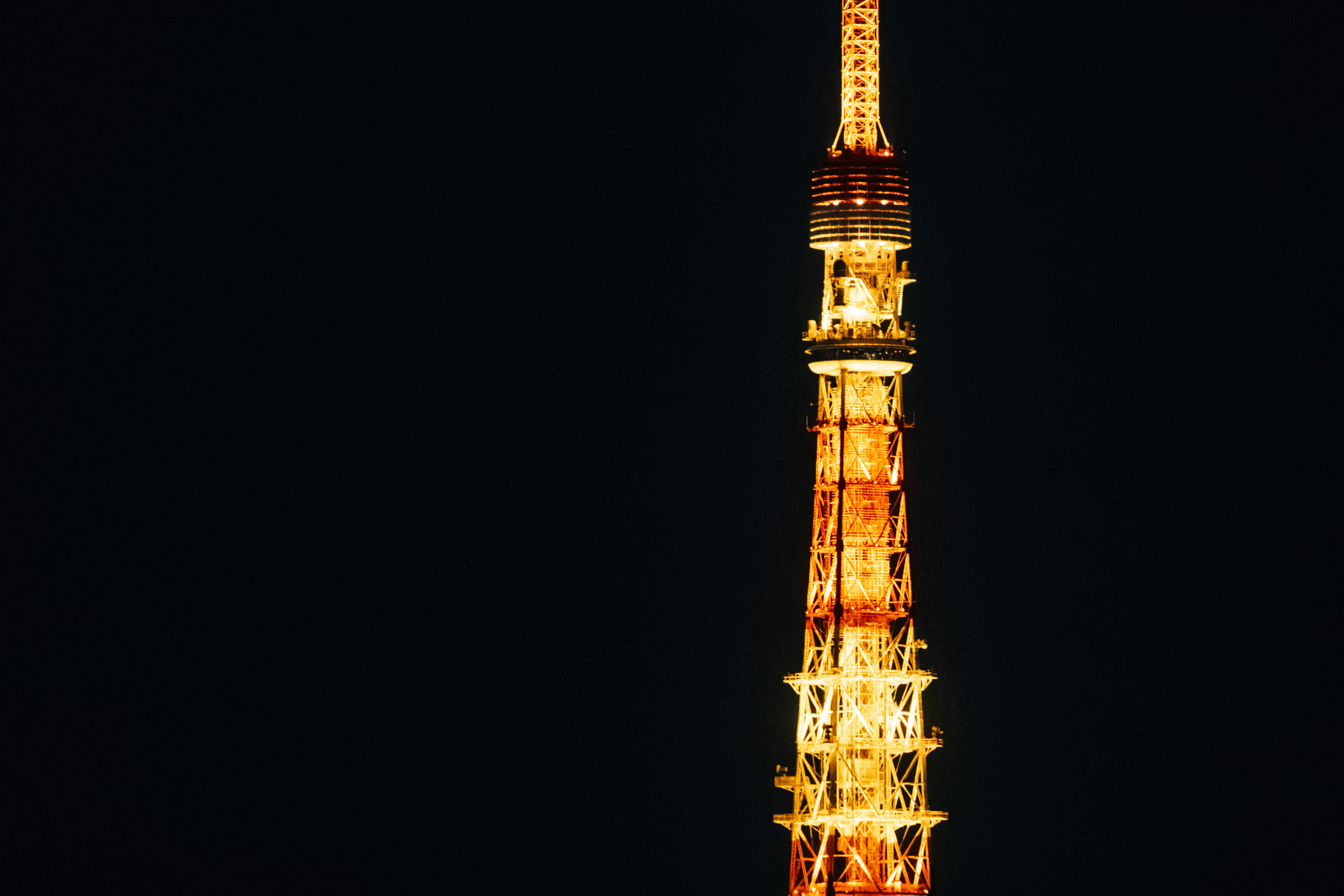 Tokyo tower illuminated at night against dark sky
