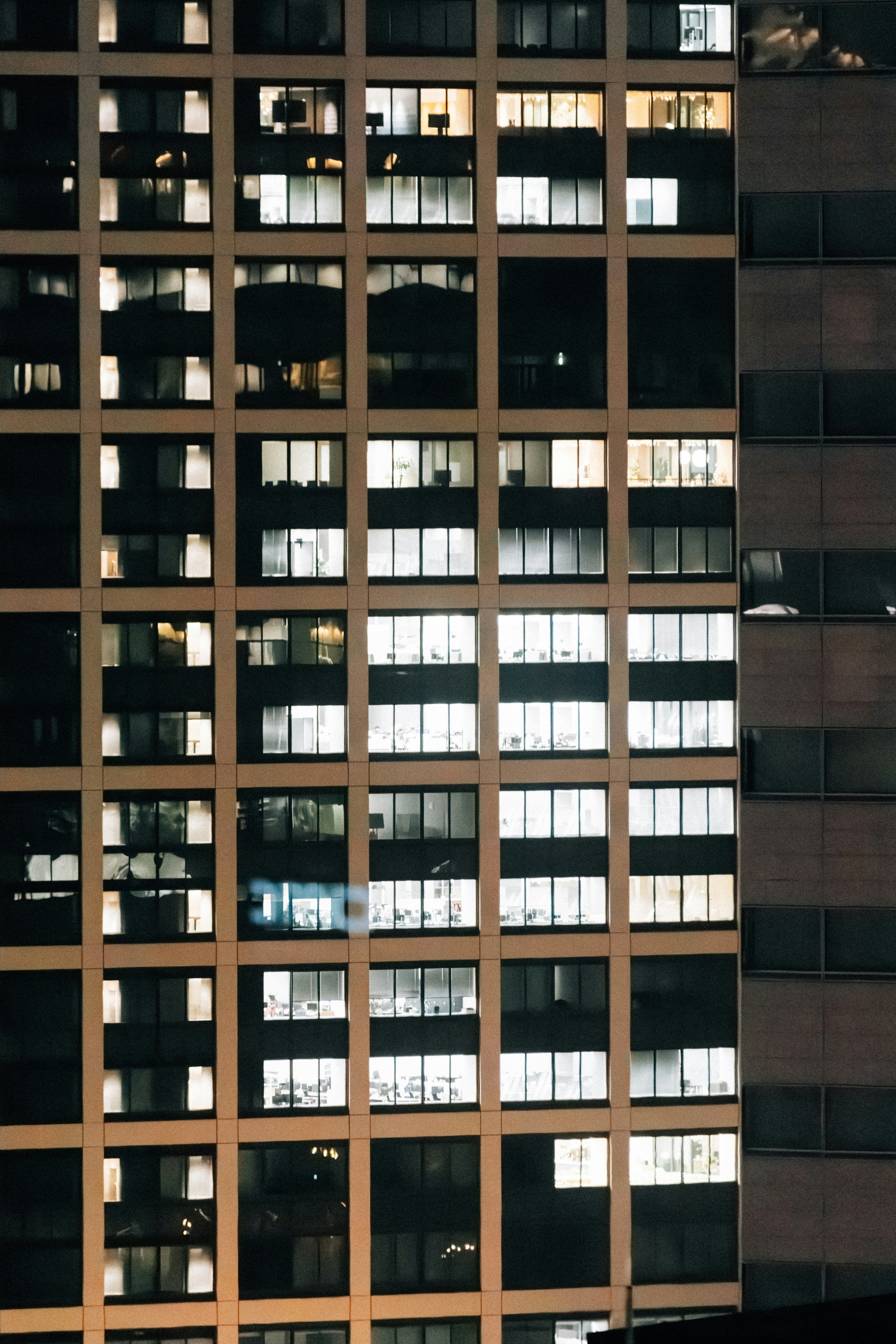 Modern office building windows lit up at night