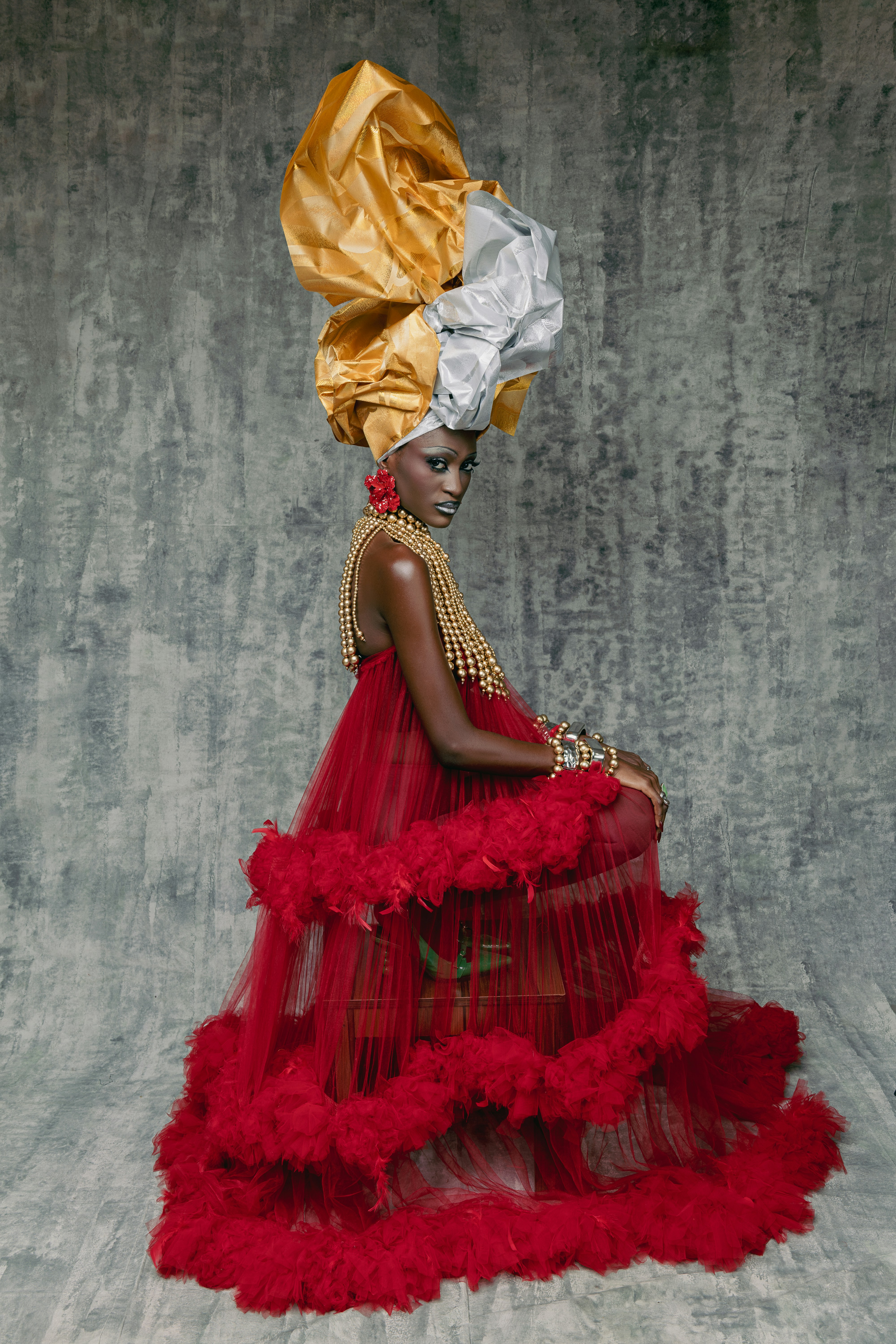 凝った赤いドレスと金色のヘッドピースをかぶった女性
