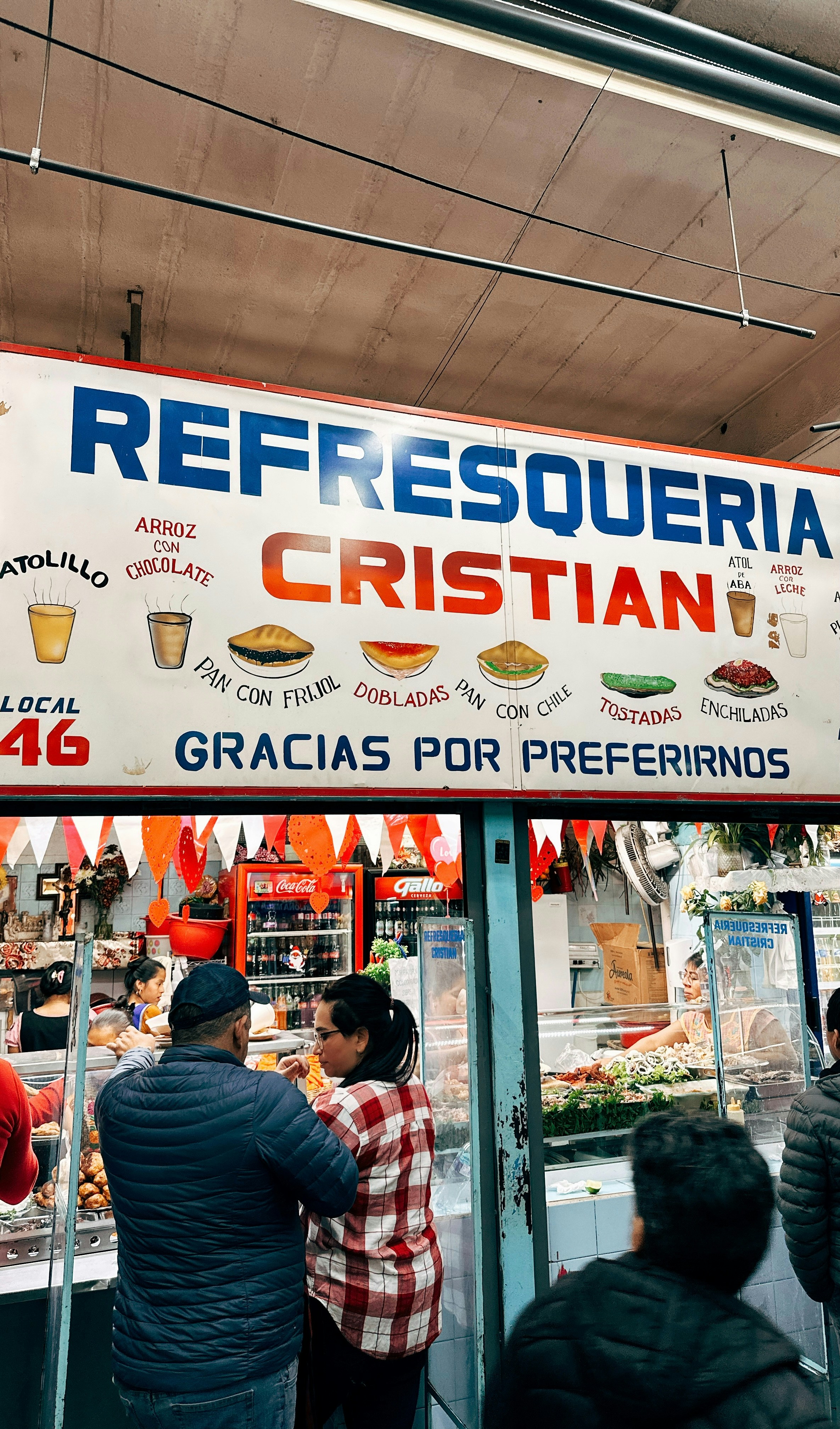 Refresqueria cristian sign with customers waiting