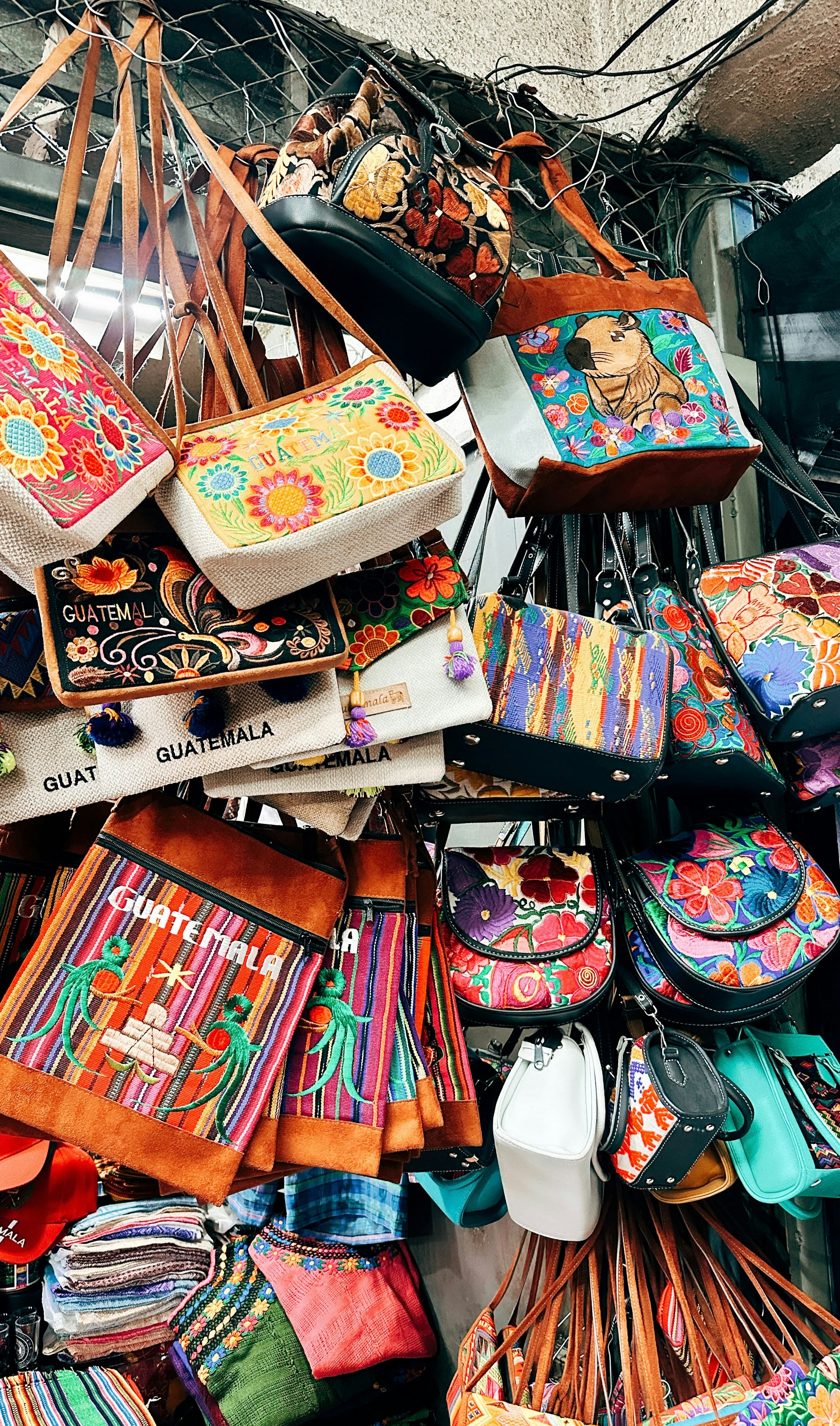 Colorful woven bags and pouches displayed at a market.