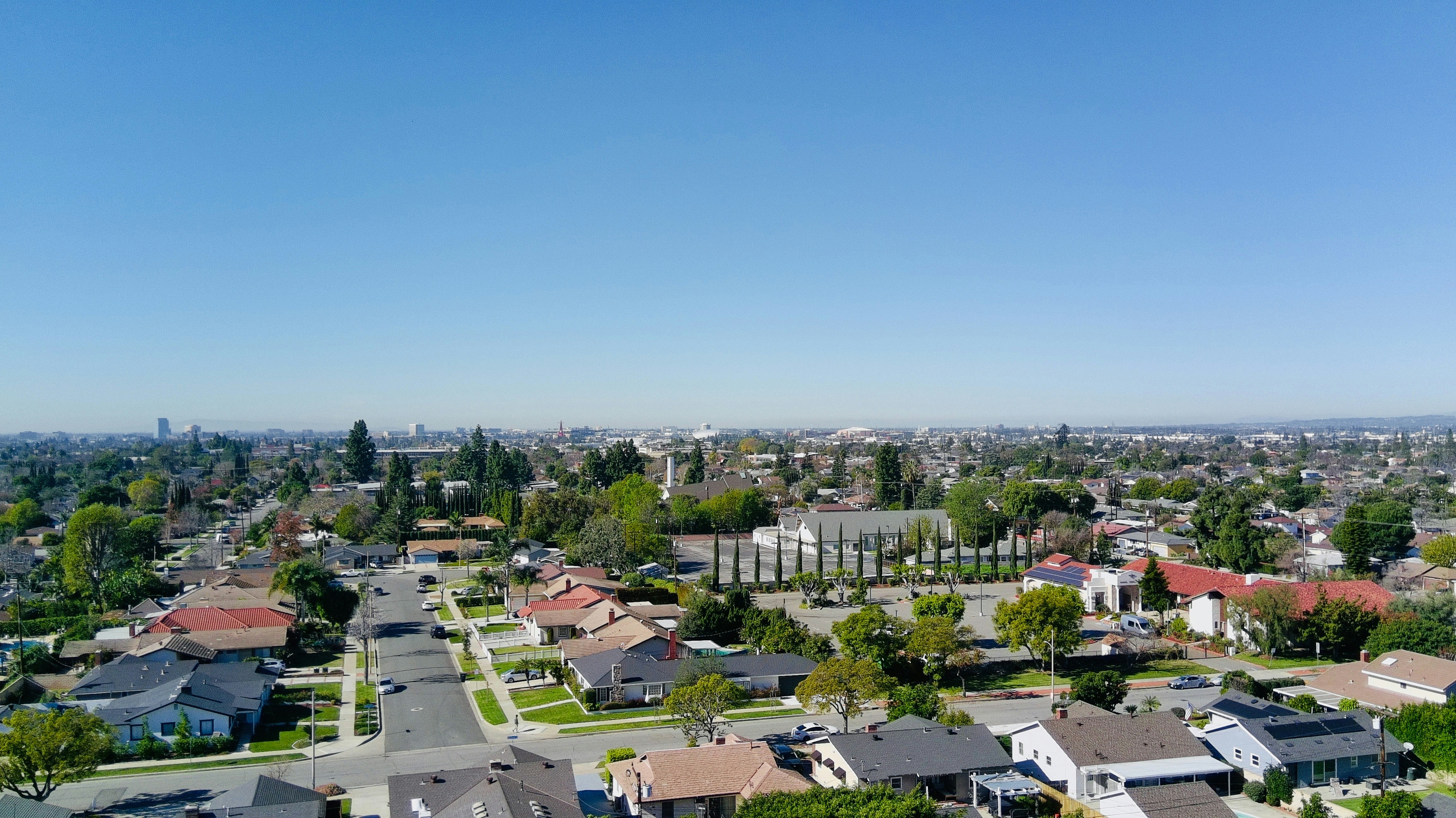 Suburban neighborhood with houses and trees under clear sky.
