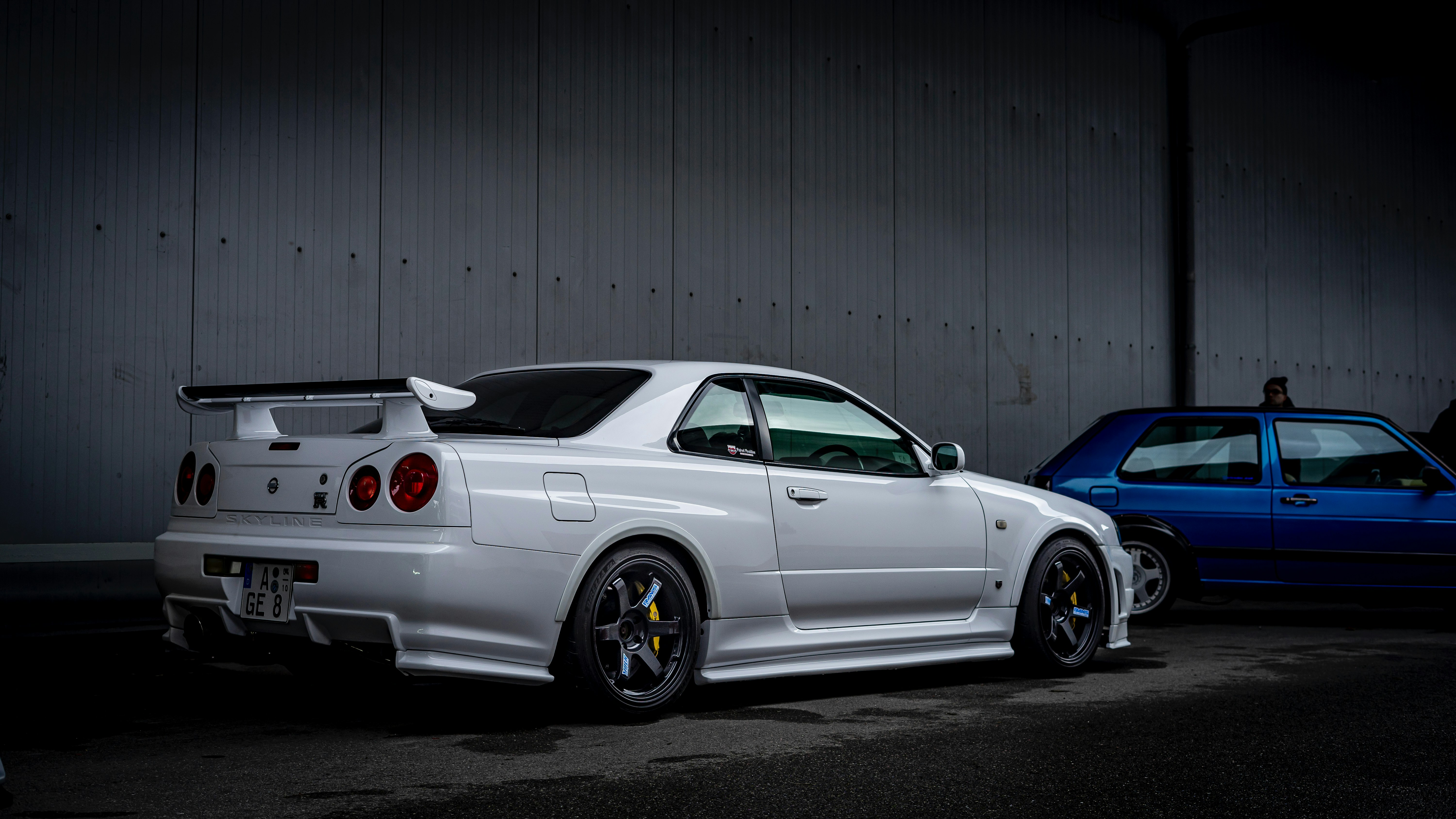 White sports car parked under a bridge.
