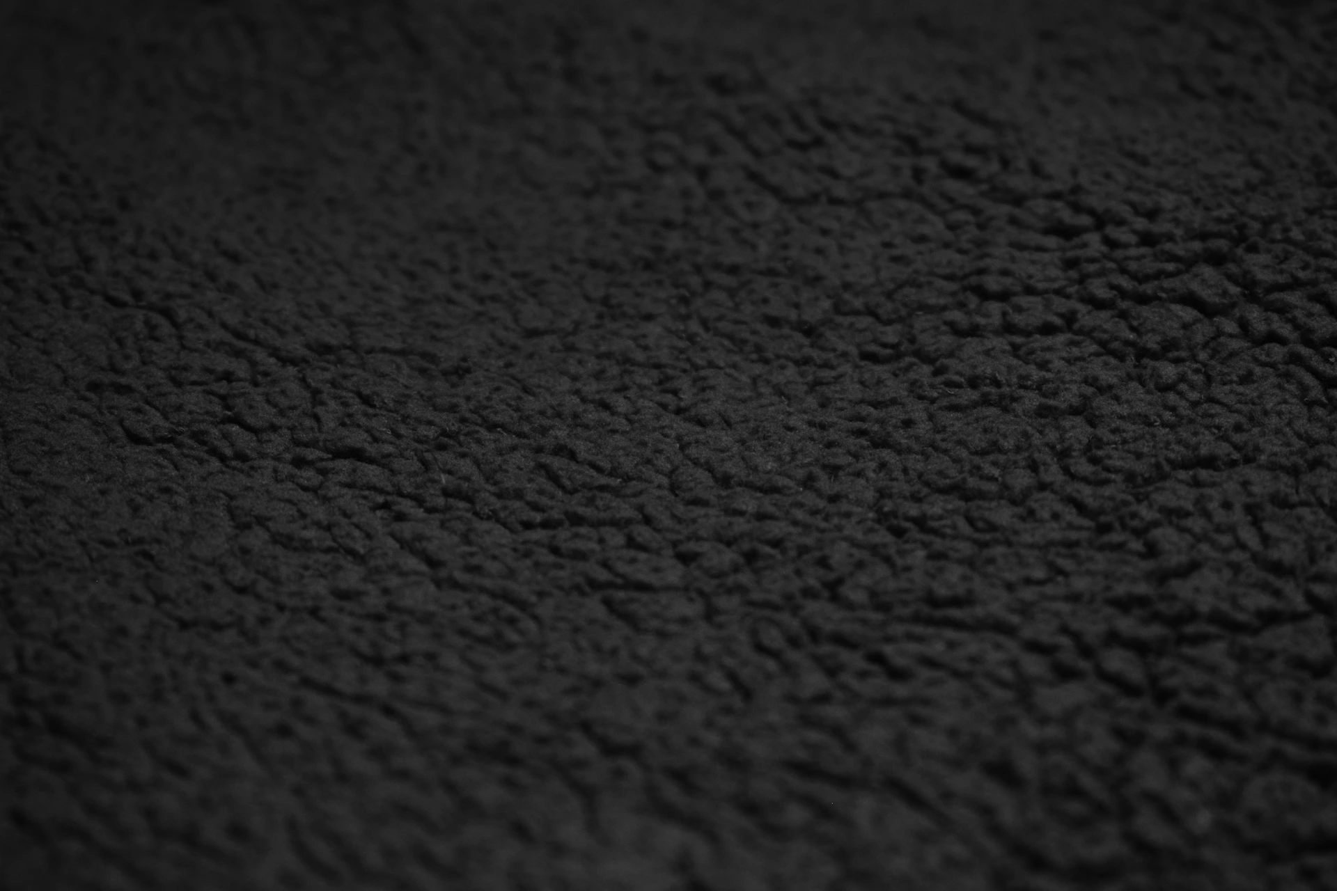 A dark, textured background with subtle ridges.