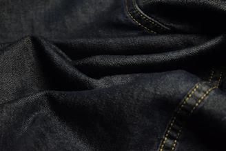 Close-up of dark blue denim fabric with stitching