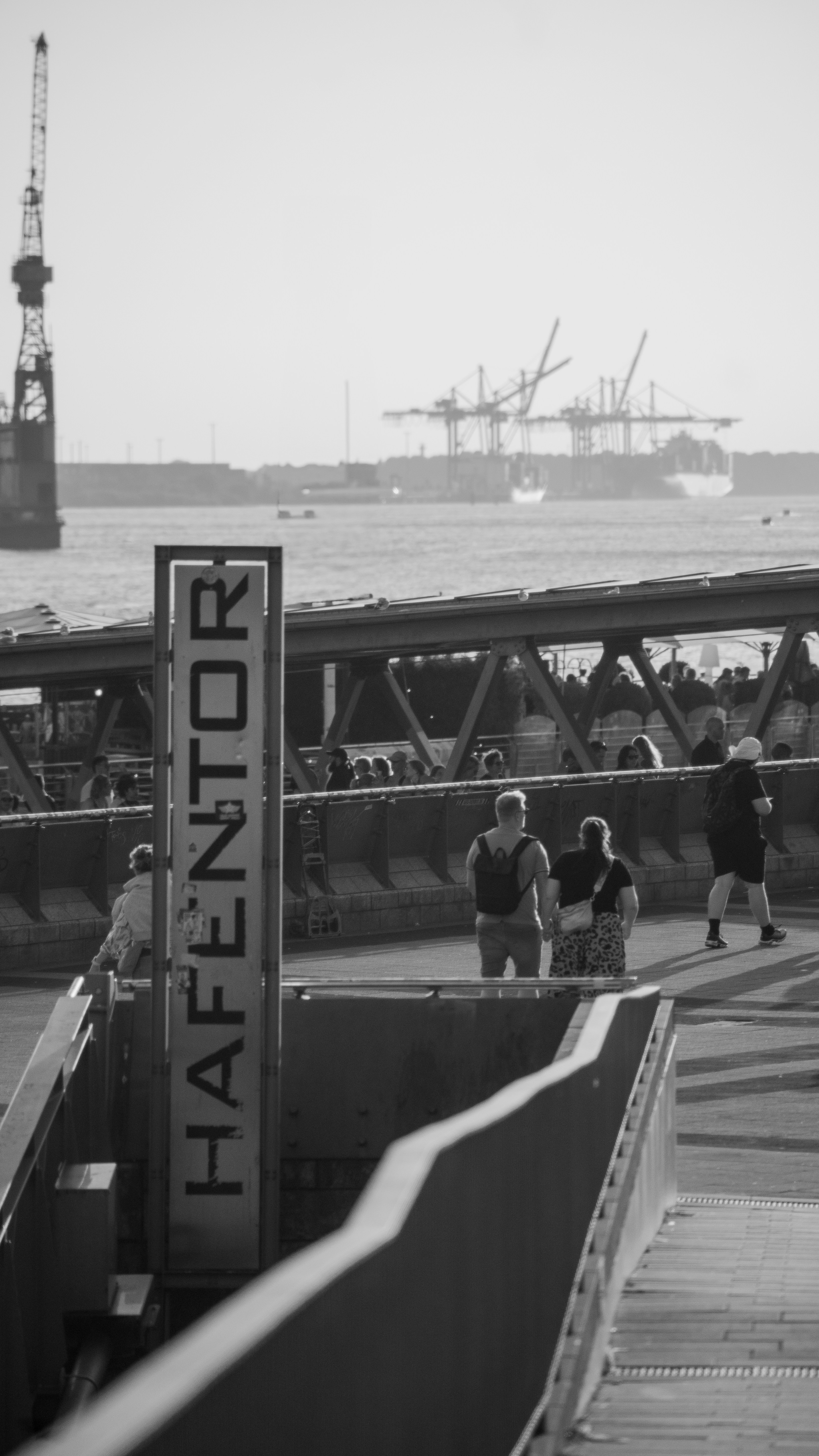 Les gens passent devant un panneau à l’entrée d’un port.