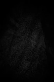 A dark, textured background with subtle white speckles.