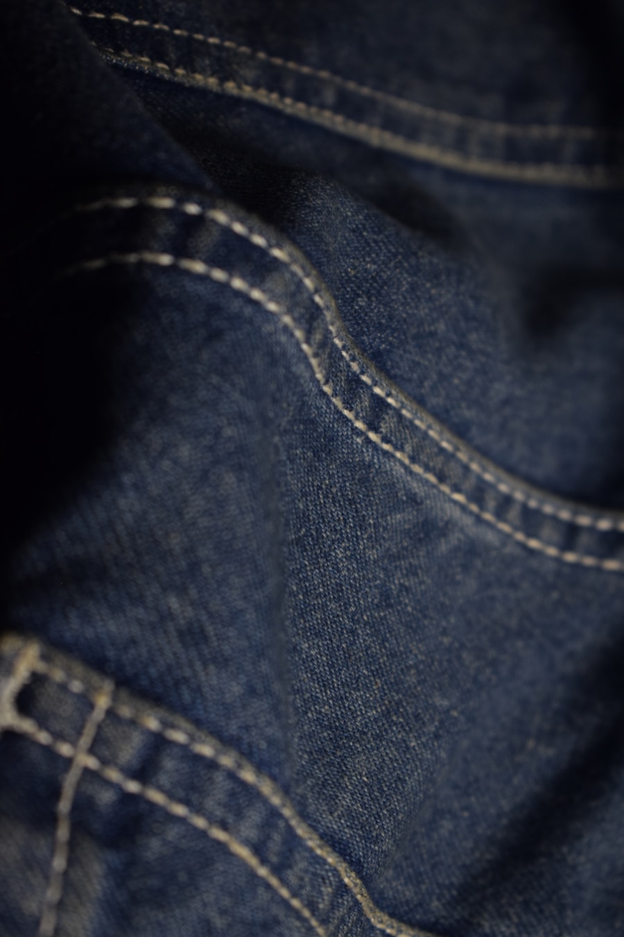 Denim azul con pespunte blanco — close-up de calidad