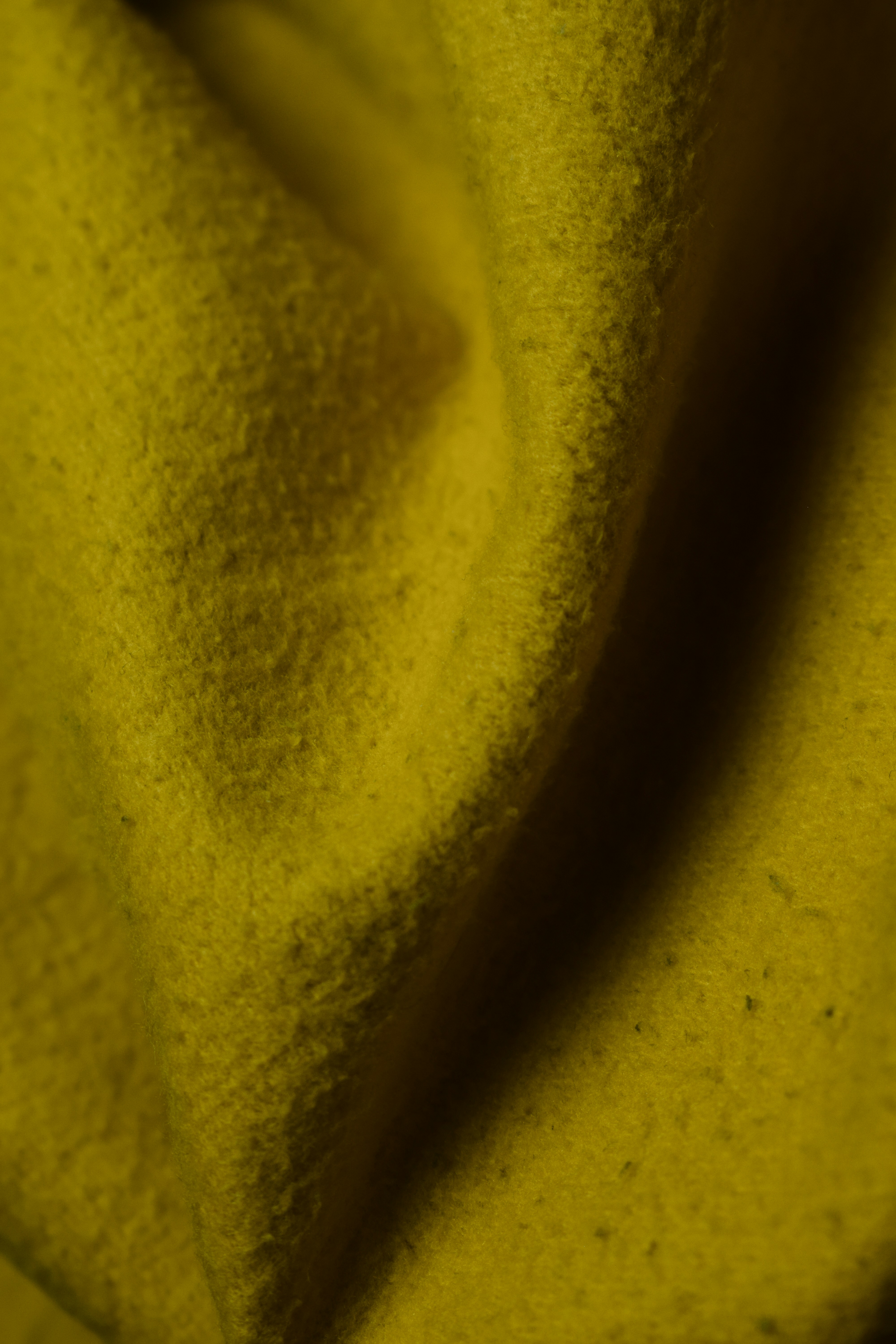 Close-up of yellow textured fabric with folds