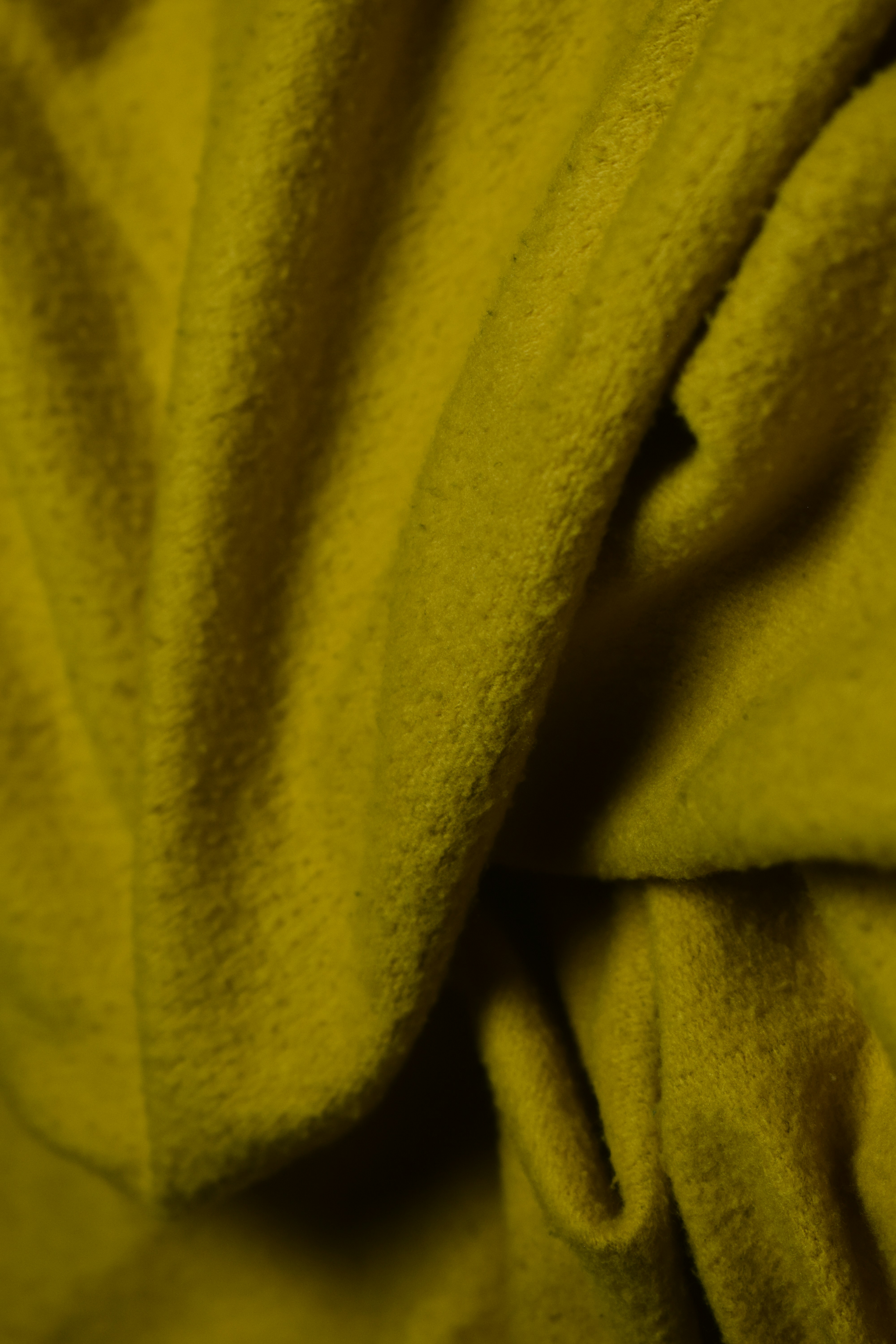 Textured yellow fabric folds with soft lighting