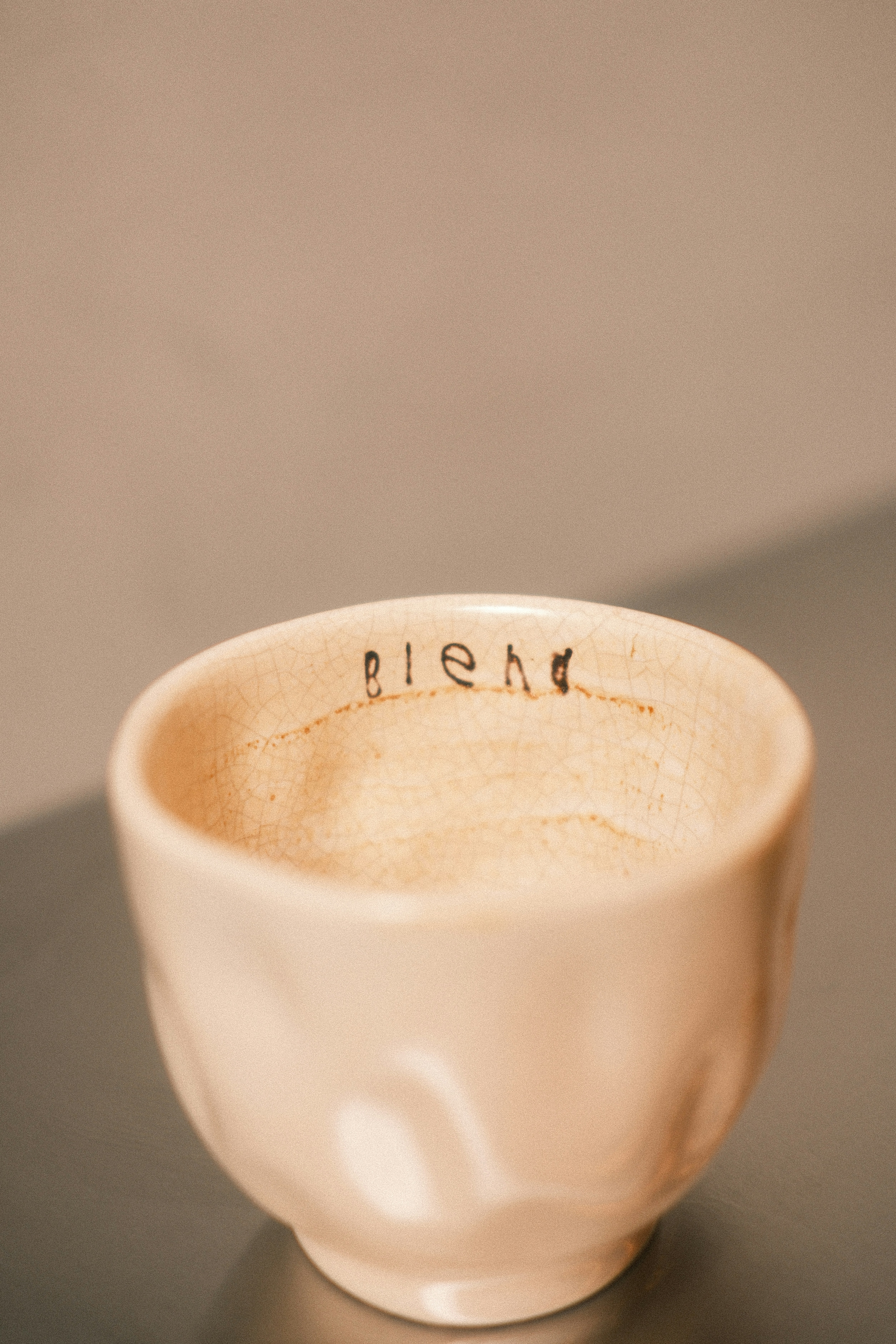 A small ceramic bowl with the word 'blend' written inside.