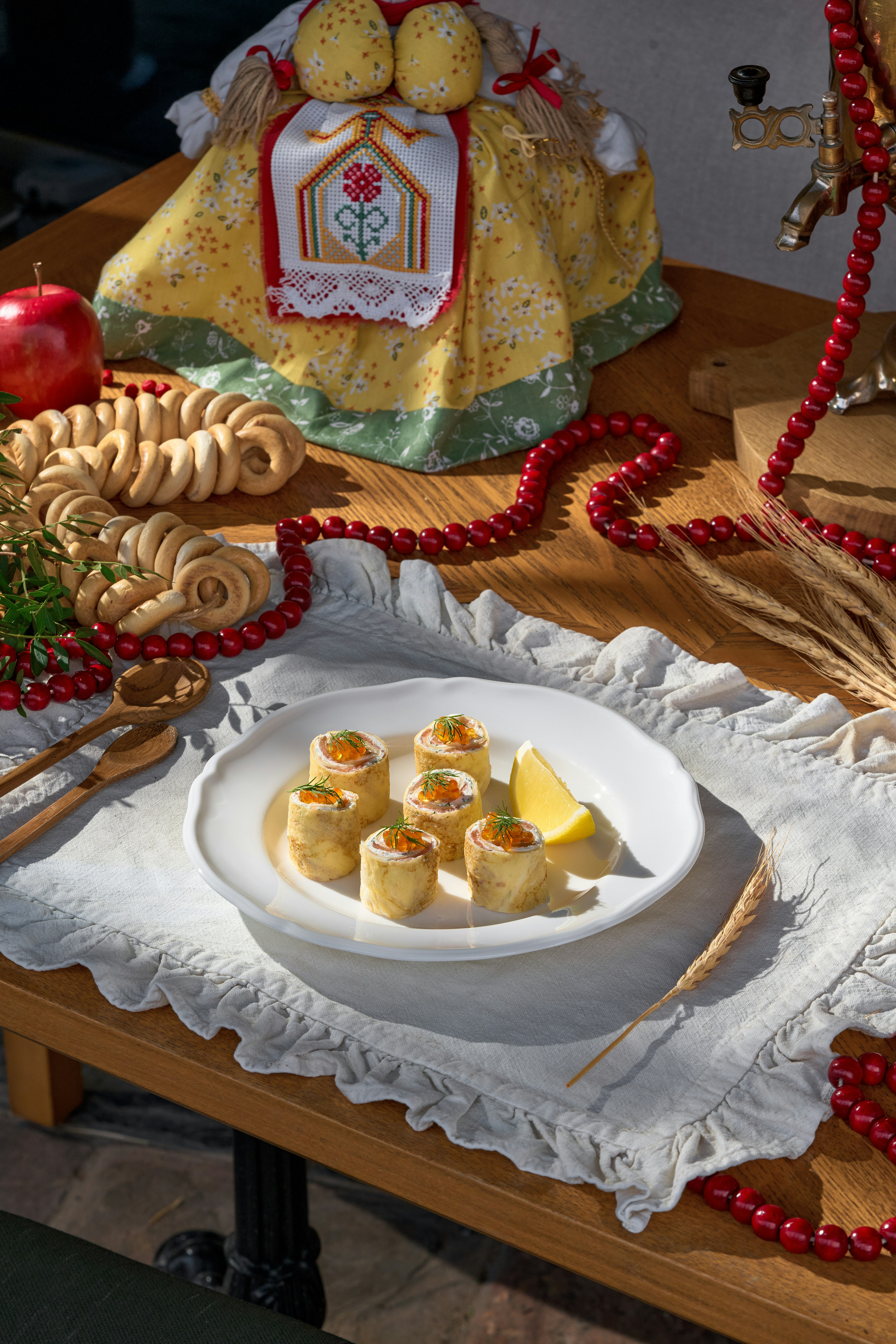 Gerollte Vorspeisen mit Kaviar und Zitrone auf einem weißen Teller.