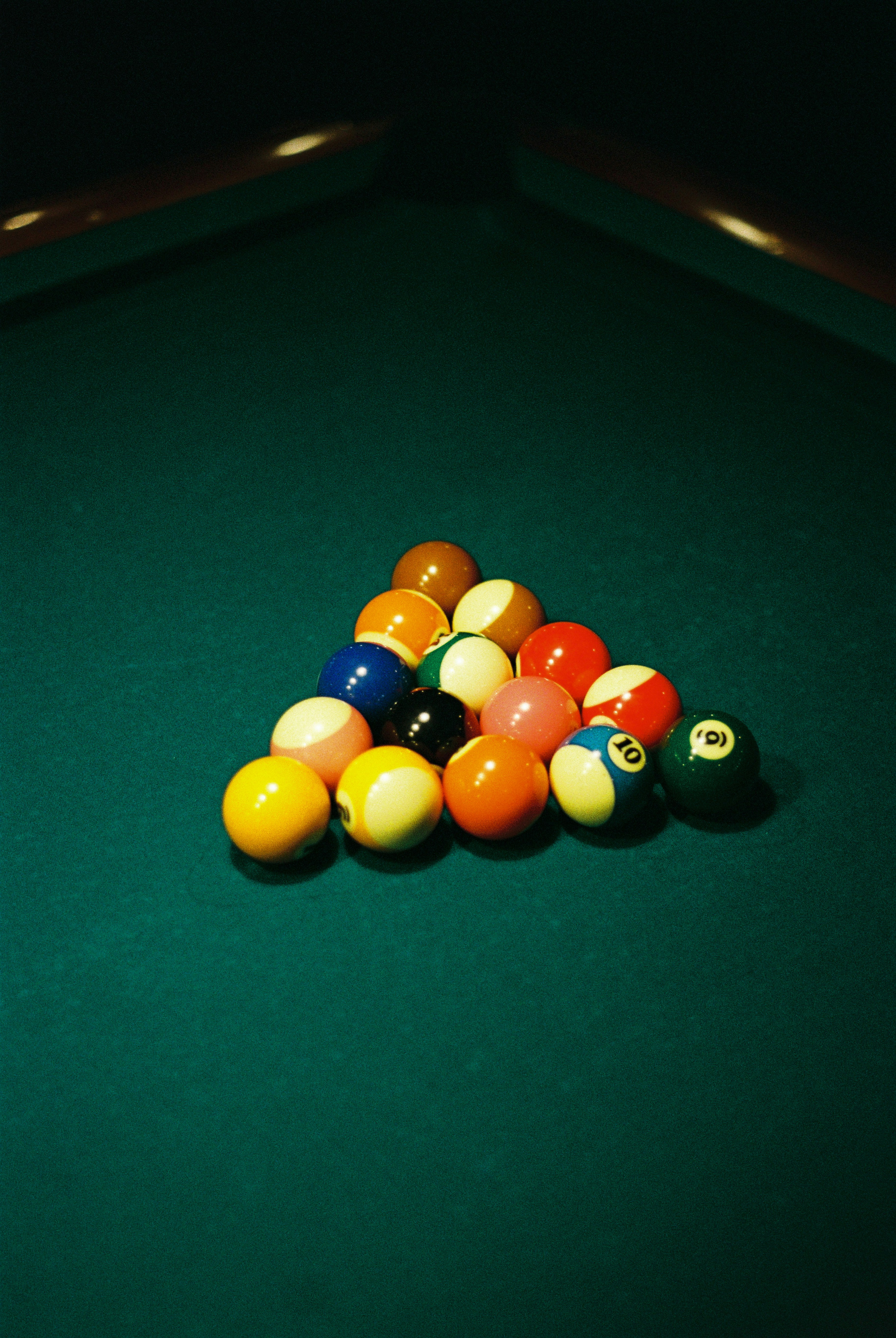 Billiard balls racked on a green felt table.