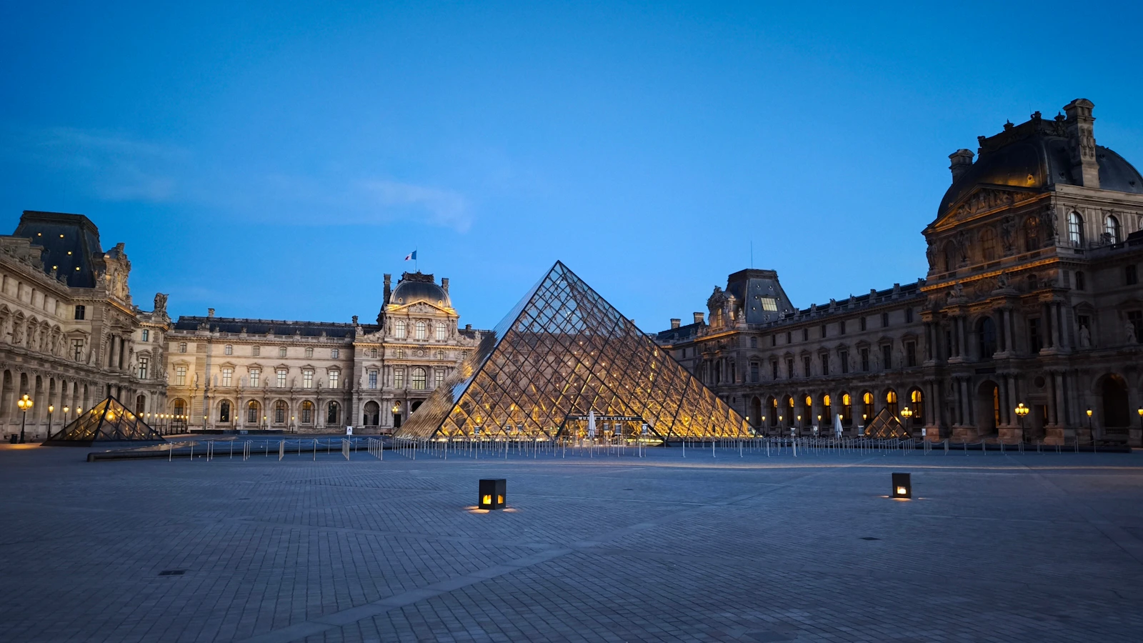 Louvre pyramid and museum at dusk