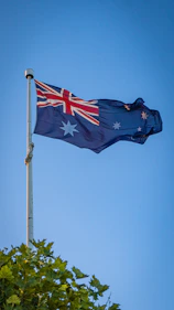 Australian flag waving against a clear blue sky.